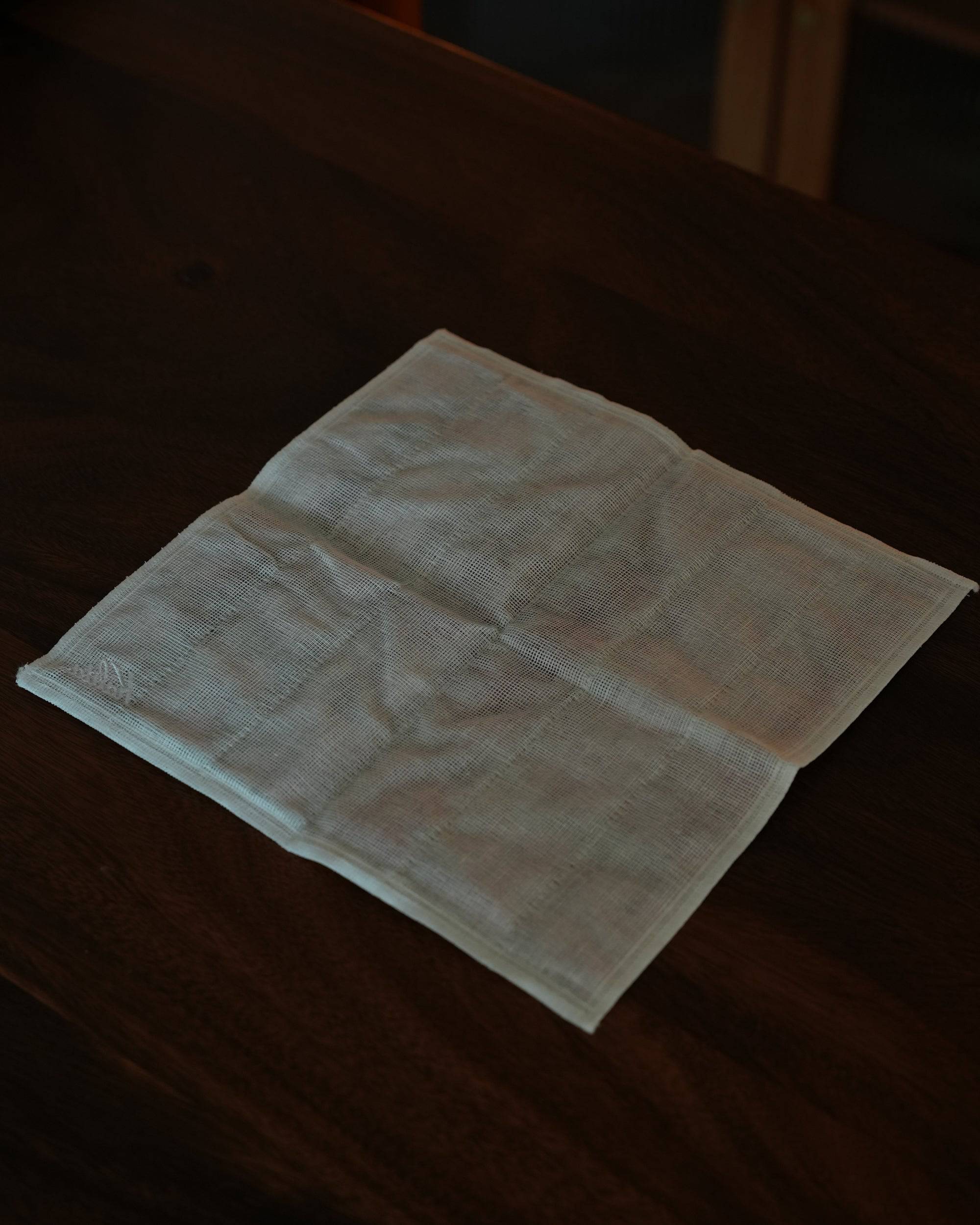 Kalita classic red plaid cloth for pour-over coffee, 100% cotton, 30x30cm, folded neatly on dark wooden surface in dim lighting, showcasing texture and quality