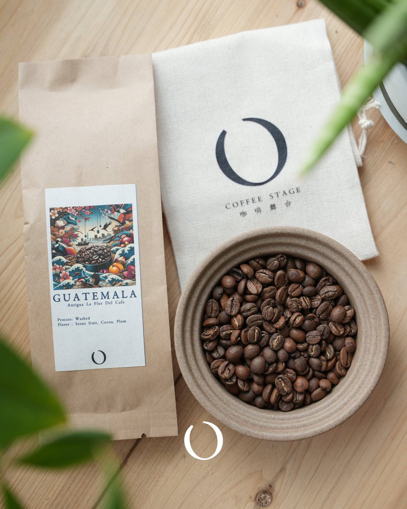 Roasted Guatemala Antigua coffee beans in ceramic bowl, Coffee Stage branded packaging, and colorful product card showcasing flavor notes, surrounded by green plant leaves