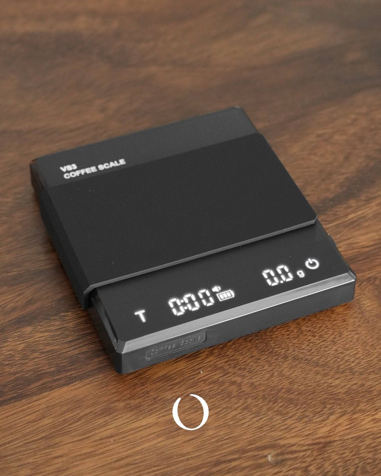 Ikape Espresso black digital coffee scale with LED display showing time and weight, placed on wooden surface. High-precision electronic scale for accurate coffee brewing measurements.