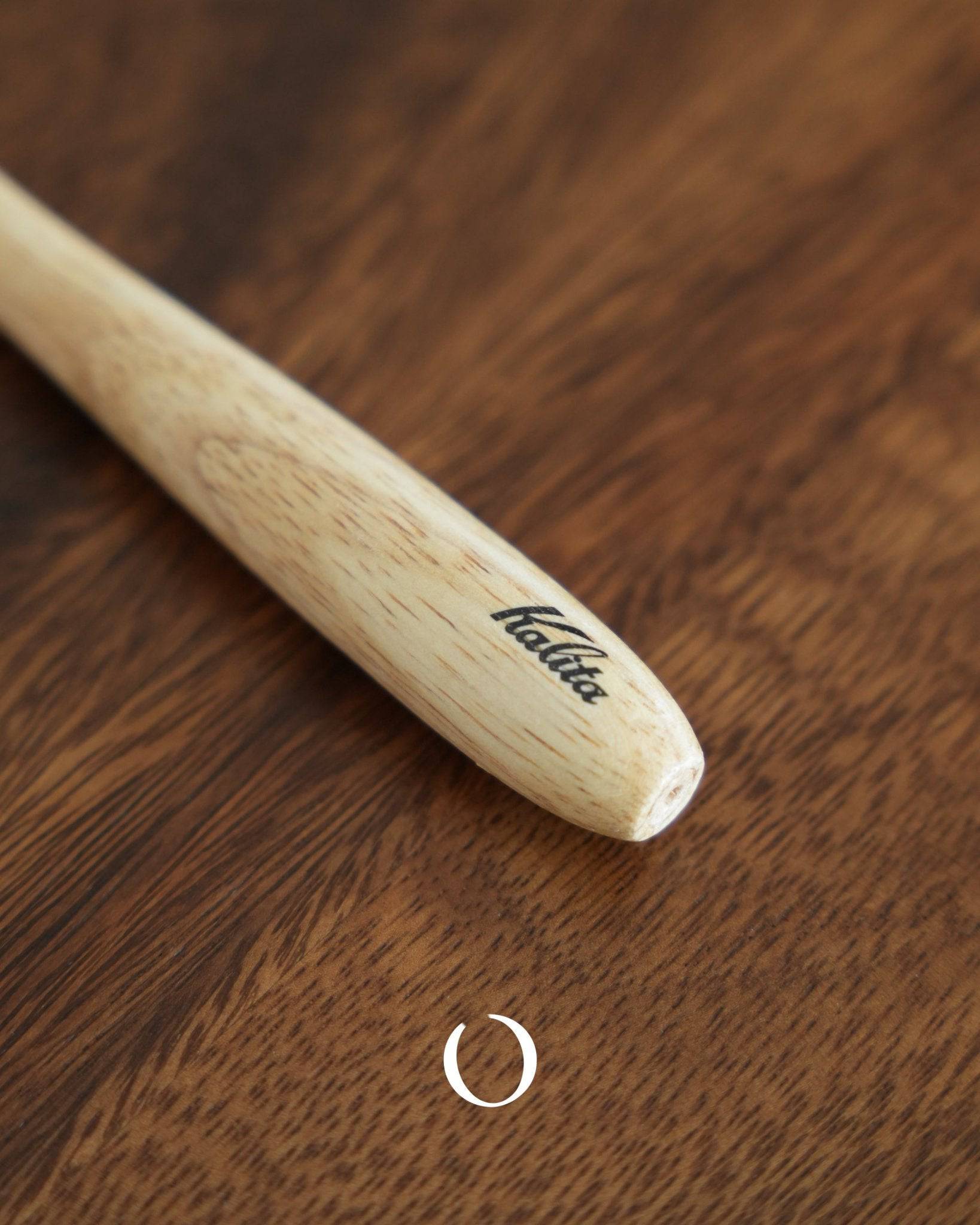 Kalita coffee cleaning brush with wooden handle and boar bristles on dark wood surface, featuring Kalita logo on handle