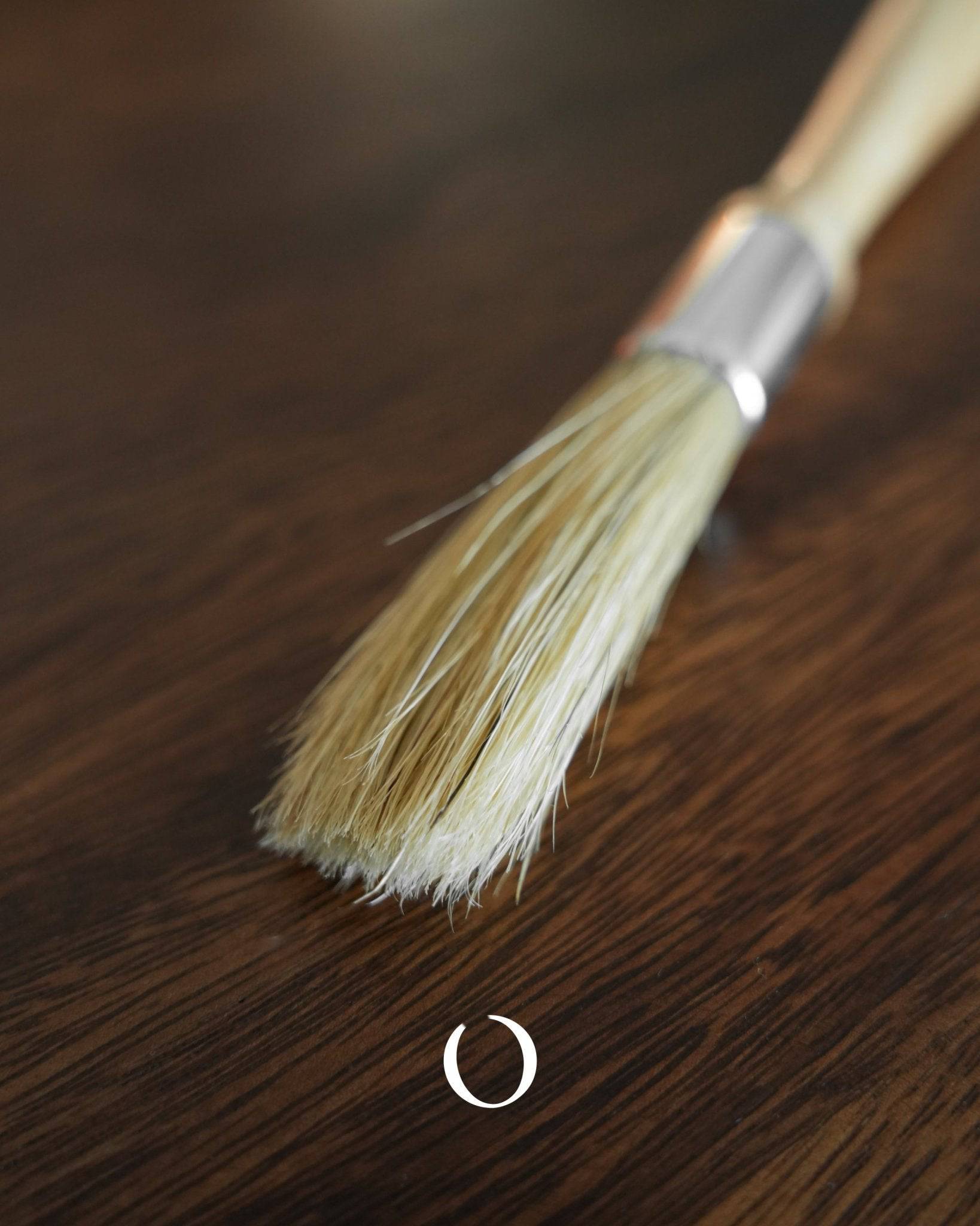 Kalita coffee cleaning brush with boar bristles and rubber wood handle, featuring aluminum band, on wooden surface