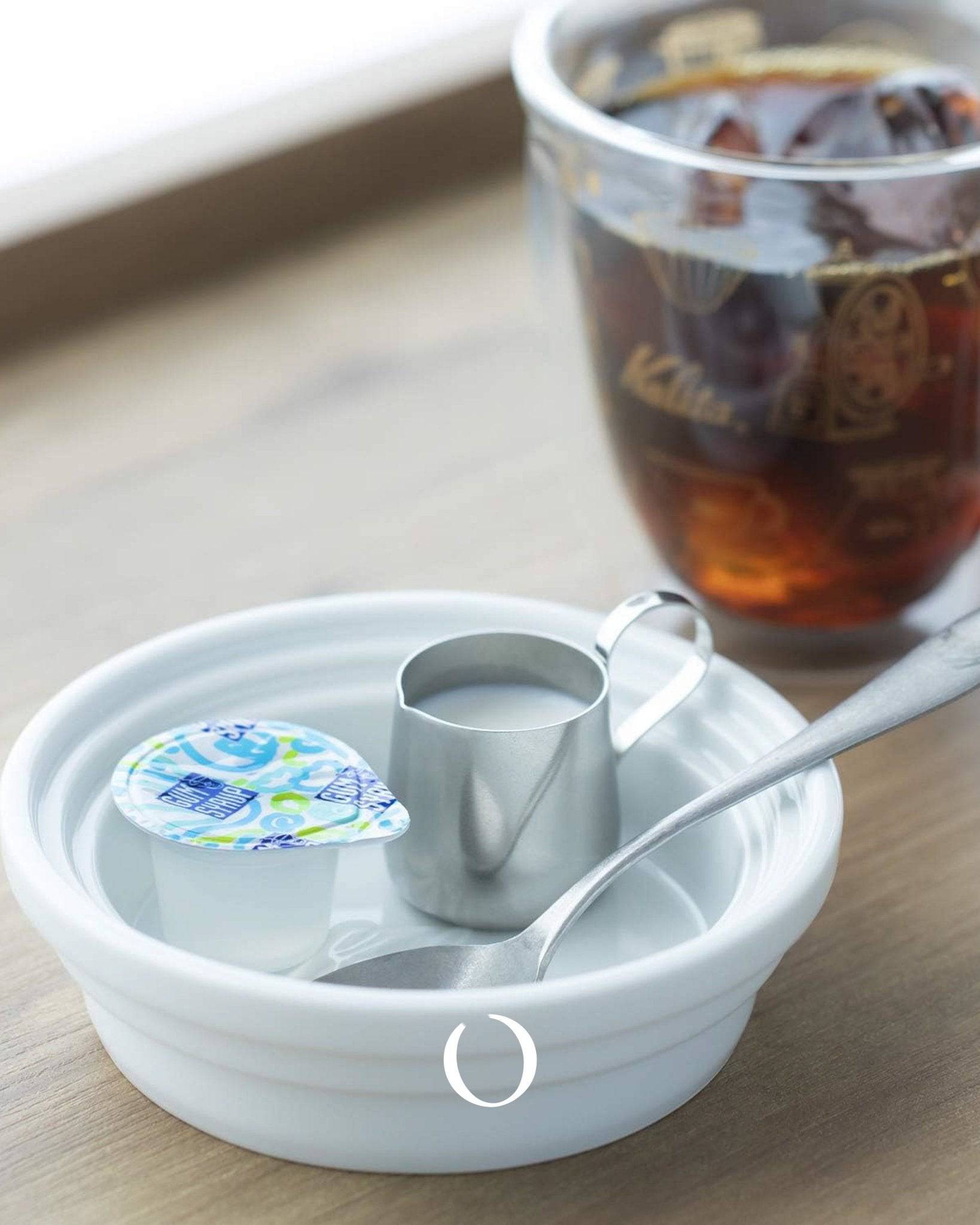 Kalita & Hasami ceramic drip tray with coffee cup, creamer, and spoon. White porcelain tray showcases Japanese craftsmanship, perfect for pour-over coffee setup. Elegant and functional design for coffee enthusiasts.