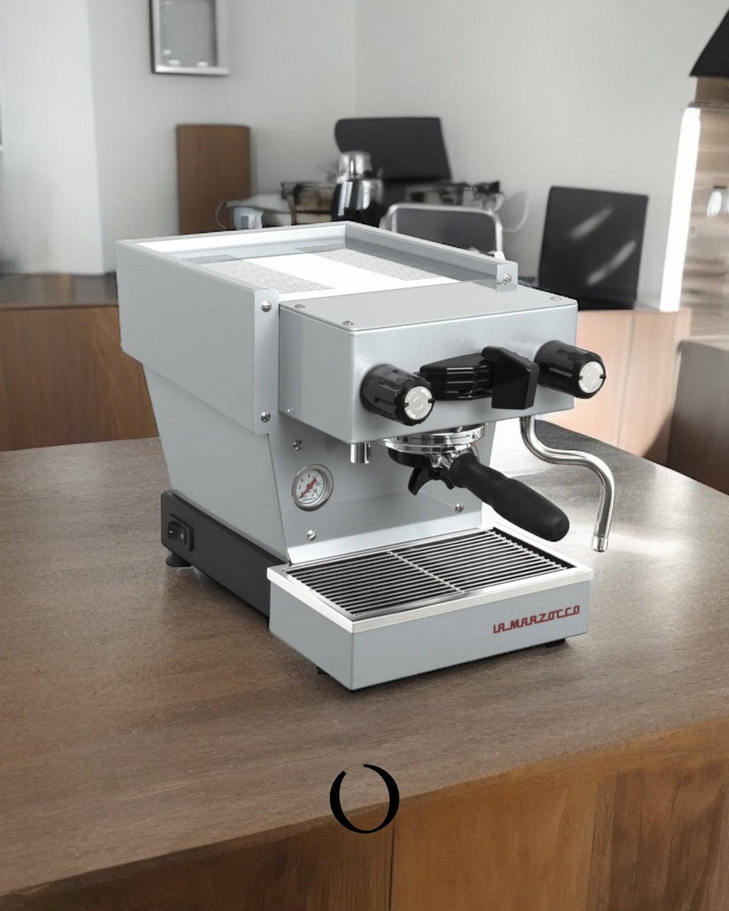 Compact La Marzocco Linea Micra espresso machine in white on wooden countertop, featuring dual boilers, pressure gauge, and steam wand. Professional-grade home coffee maker with sleek design.