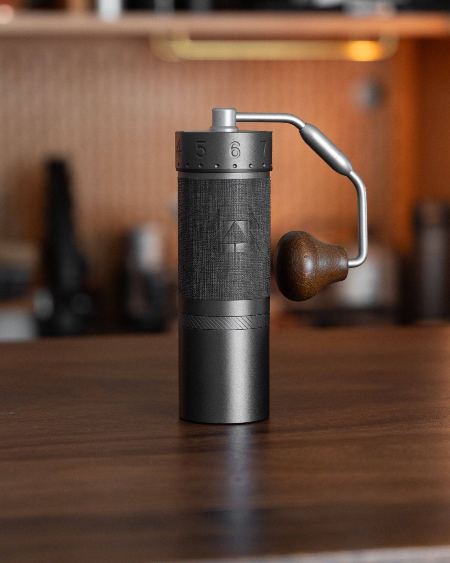 1zpresso J MAXS manual coffee grinder with sleek black design, adjustable settings, and ergonomic wooden handle on wooden table, ideal for espresso and precision grinding