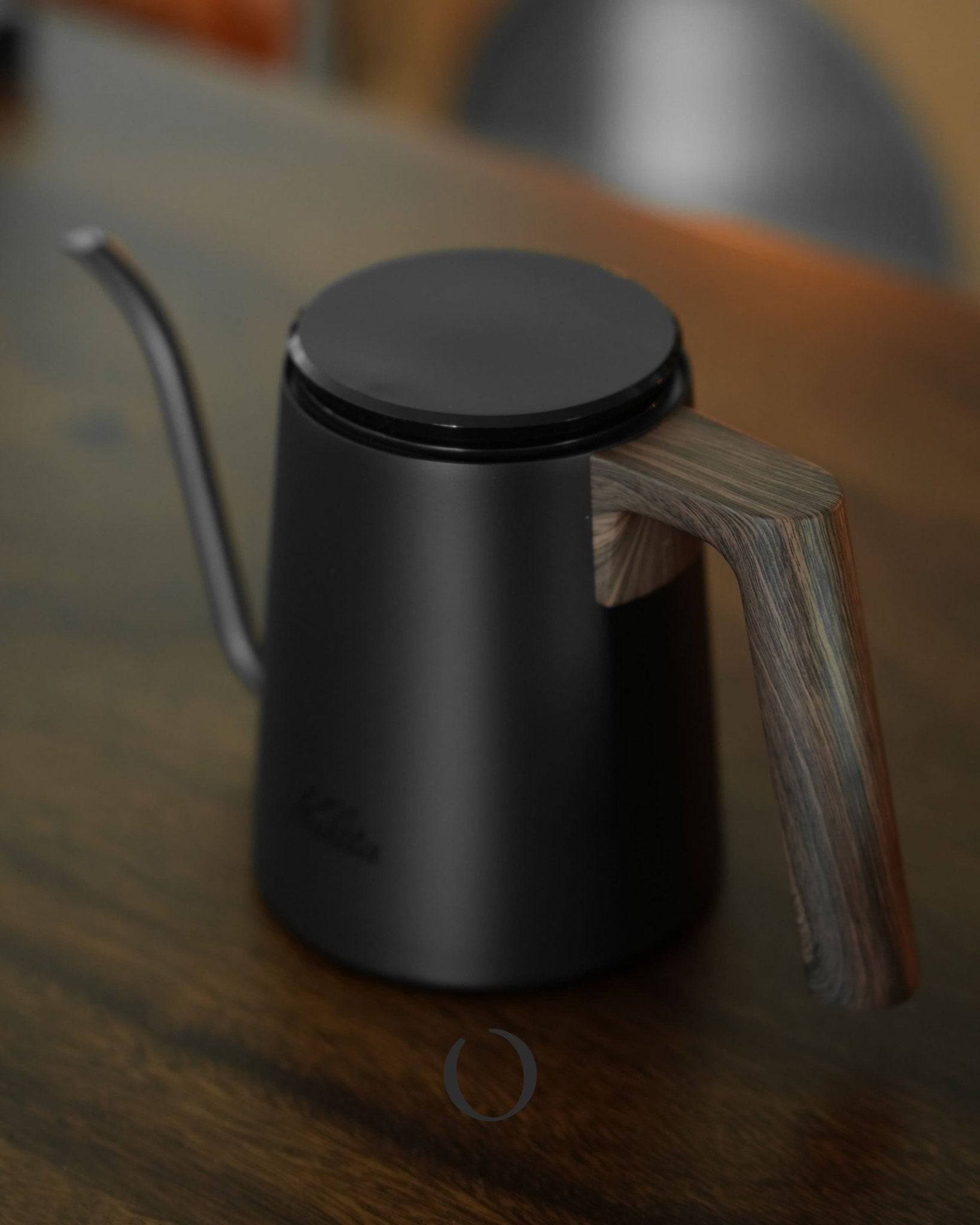 Kalita KDP-800 black coffee pour-over kettle with walnut wood grain design, 800ml capacity, sleek stainless steel body, ergonomic handle, and precision gooseneck spout for controlled pouring, sitting on wooden surface