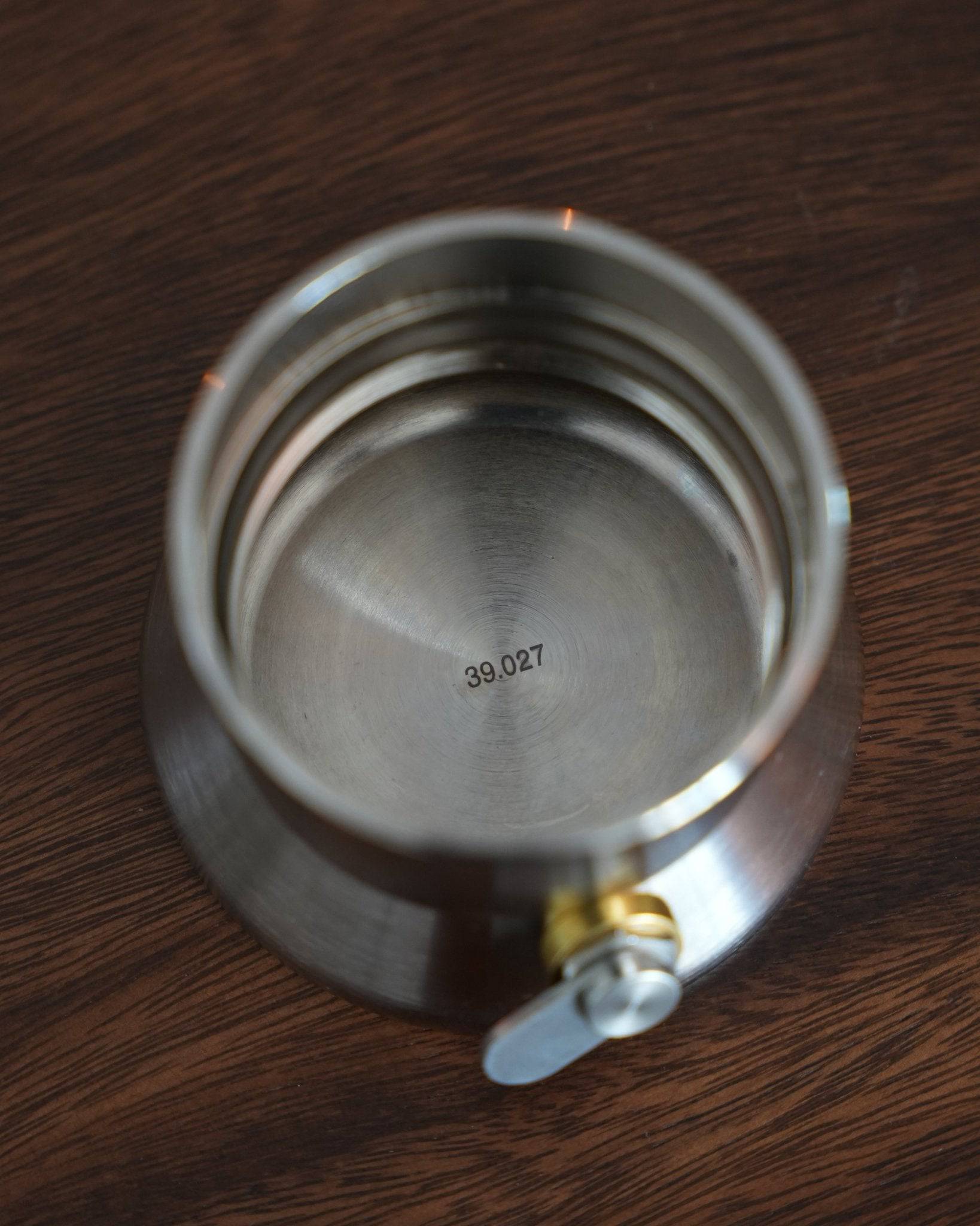 Stainless steel base of 9Barista espresso maker with serial number, showcasing its high-quality construction and precision engineering on wooden surface