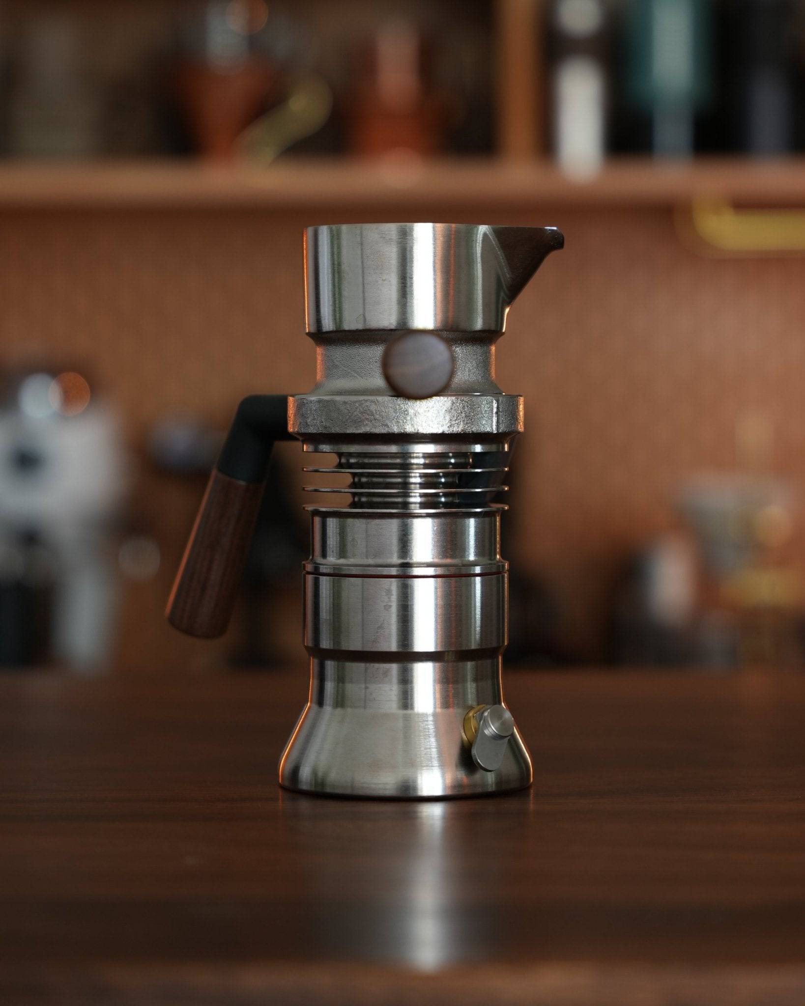 9Barista espresso machine on wooden surface, sleek stainless steel design with unique dual boiler system, compact and professional-grade for home use, showcasing innovative patented technology for perfect espresso brewing