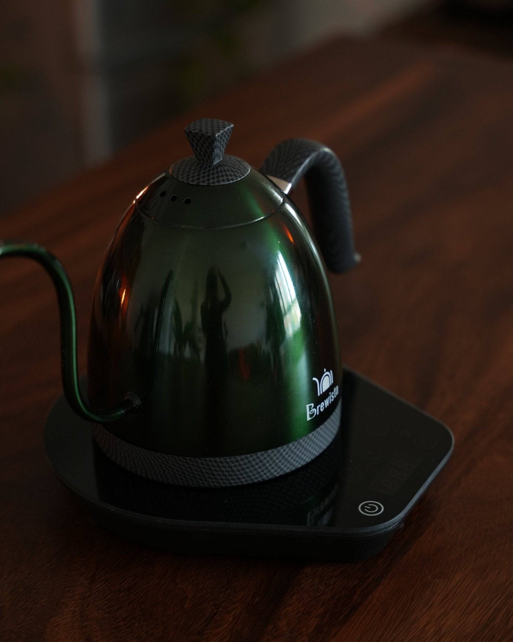 Brewista Artisan temperature control kettle in sleek green design on wooden surface, showcasing gooseneck spout and digital base for precise coffee brewing