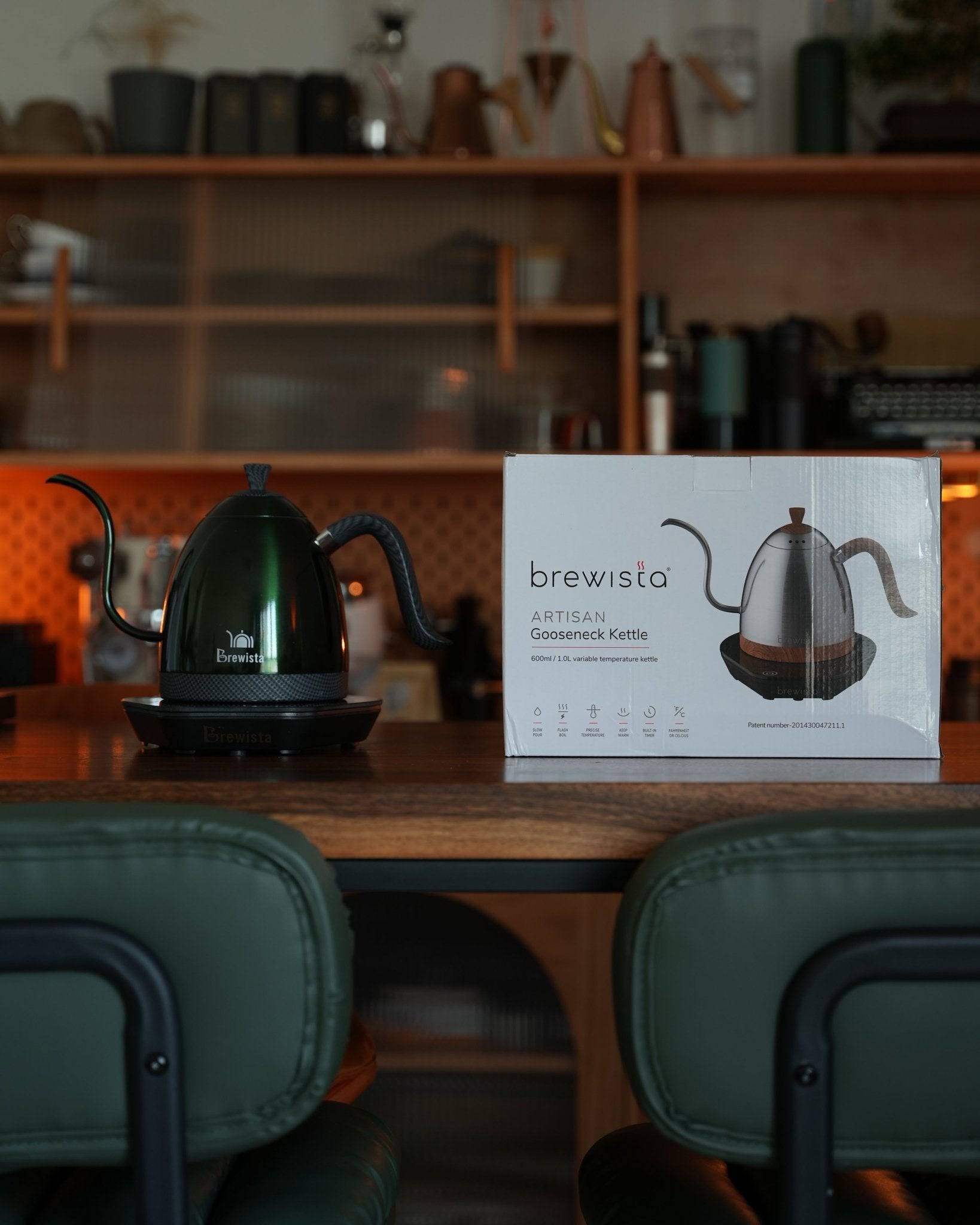 Brewista Artisan gooseneck kettle displayed on wooden counter with product box, showcasing precise temperature control for optimal coffee brewing in stylish kitchen setting