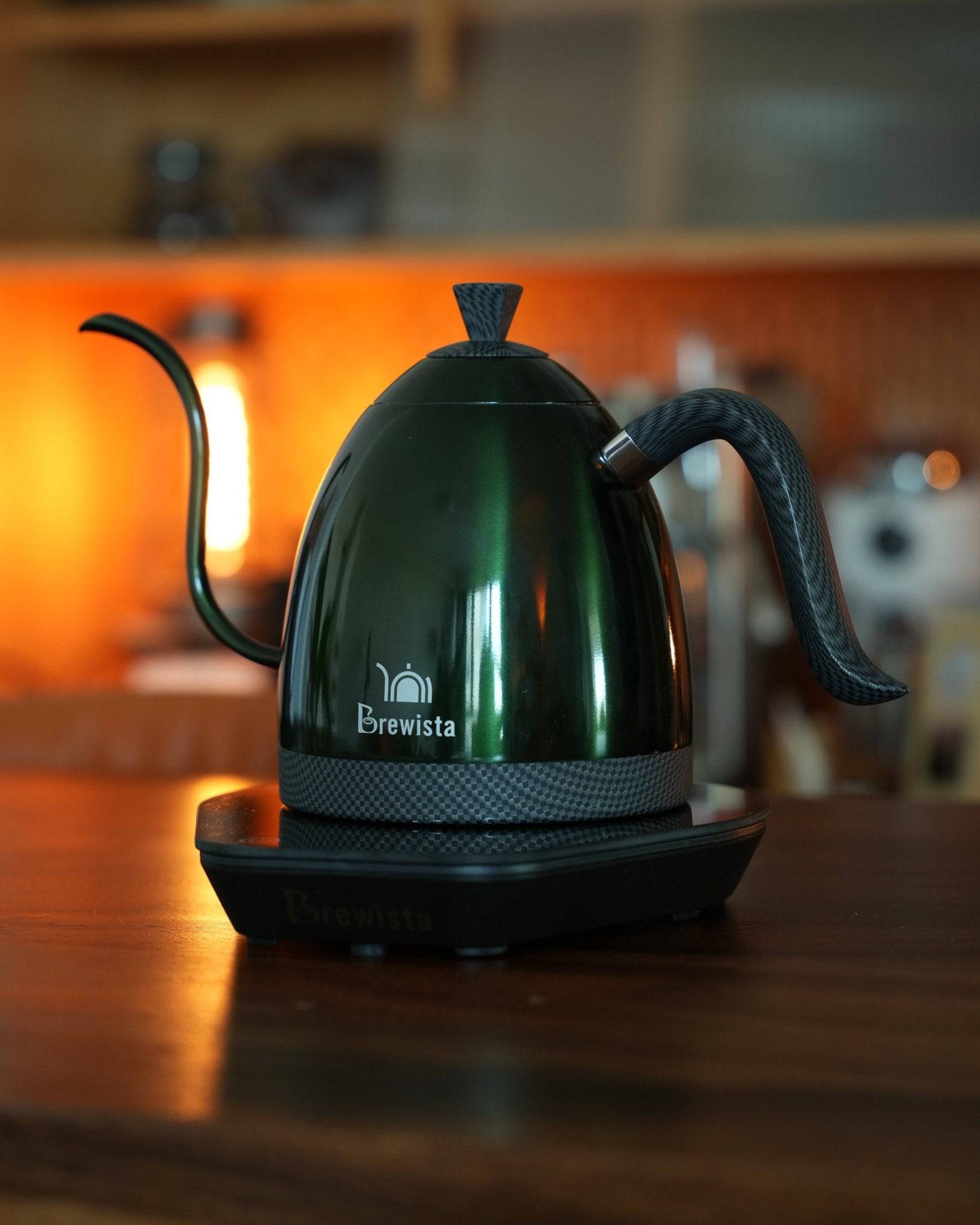 Brewista Artisan temperature-controlled kettle with sleek green design, gooseneck spout, and digital base, showcased in warm kitchen lighting for precision coffee brewing