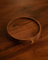 Elegant Holzlotz black walnut wood coffee tray with golden accent, circular design, warm brown tones, engraved logo, and smooth finish, perfect for serving espresso or as a decorative piece