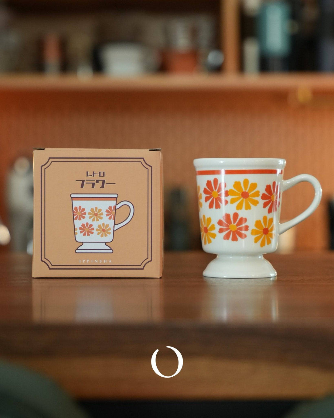 Vintage ippinsha Showa-era coffee cup with orange floral pattern, displayed next to its retro-style packaging box on wooden surface. Nostalgic Japanese ceramic mug design, 250ml capacity, perfect for daily use or gifting.