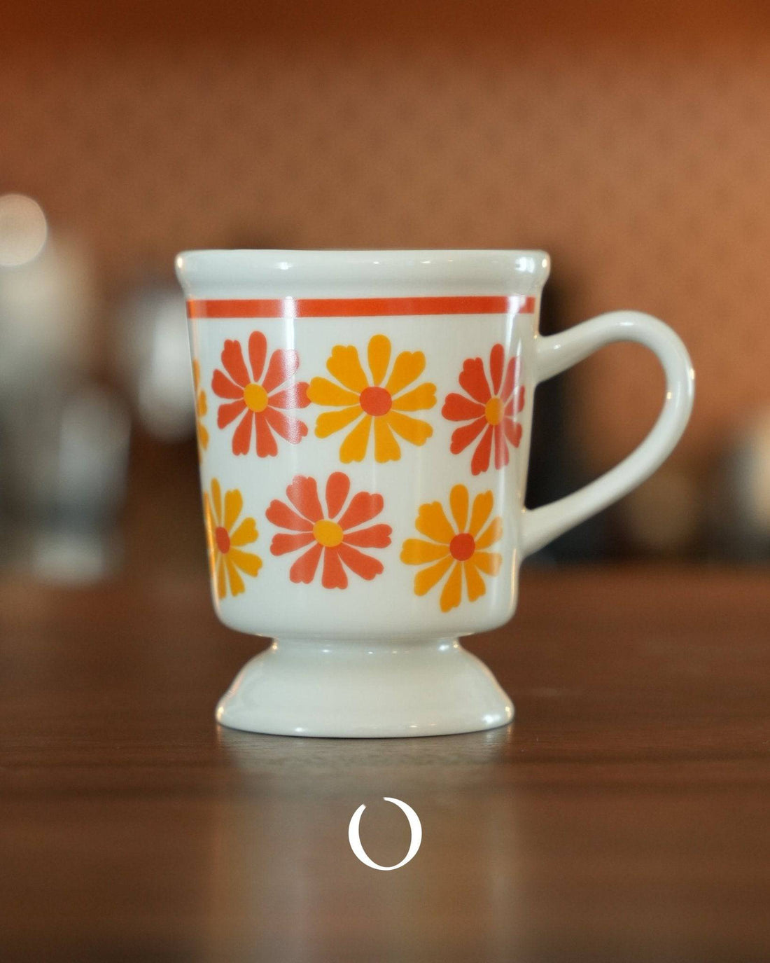 Vintage Ippinsha Showa-era coffee cup with orange and yellow floral pattern, white ceramic, footed design, retro style mug on wooden surface, nostalgic Japanese kitchenware