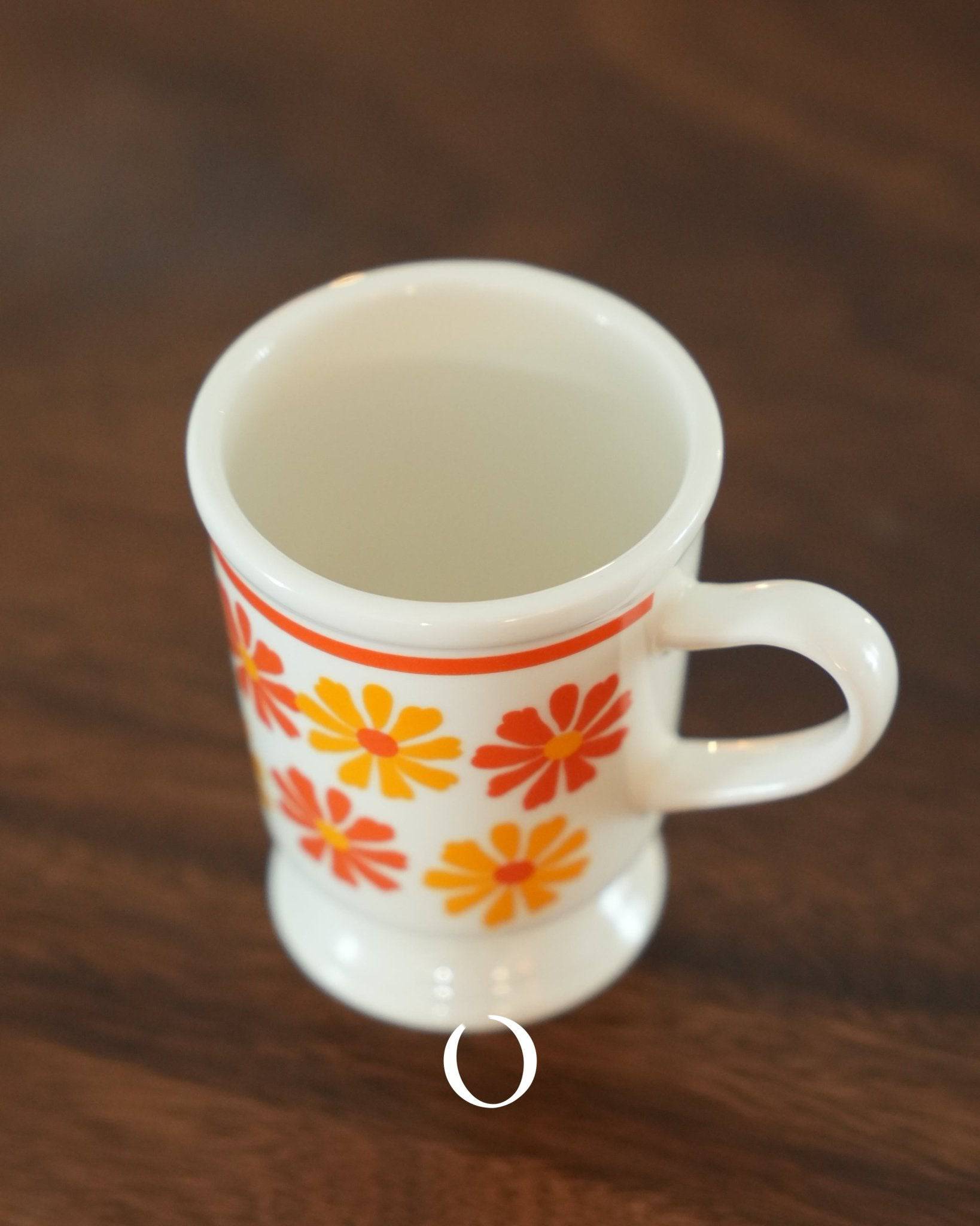 Vintage ippinsha Showa era coffee cup with orange and yellow floral pattern, ceramic material, 250ml capacity, retro design on wooden surface
