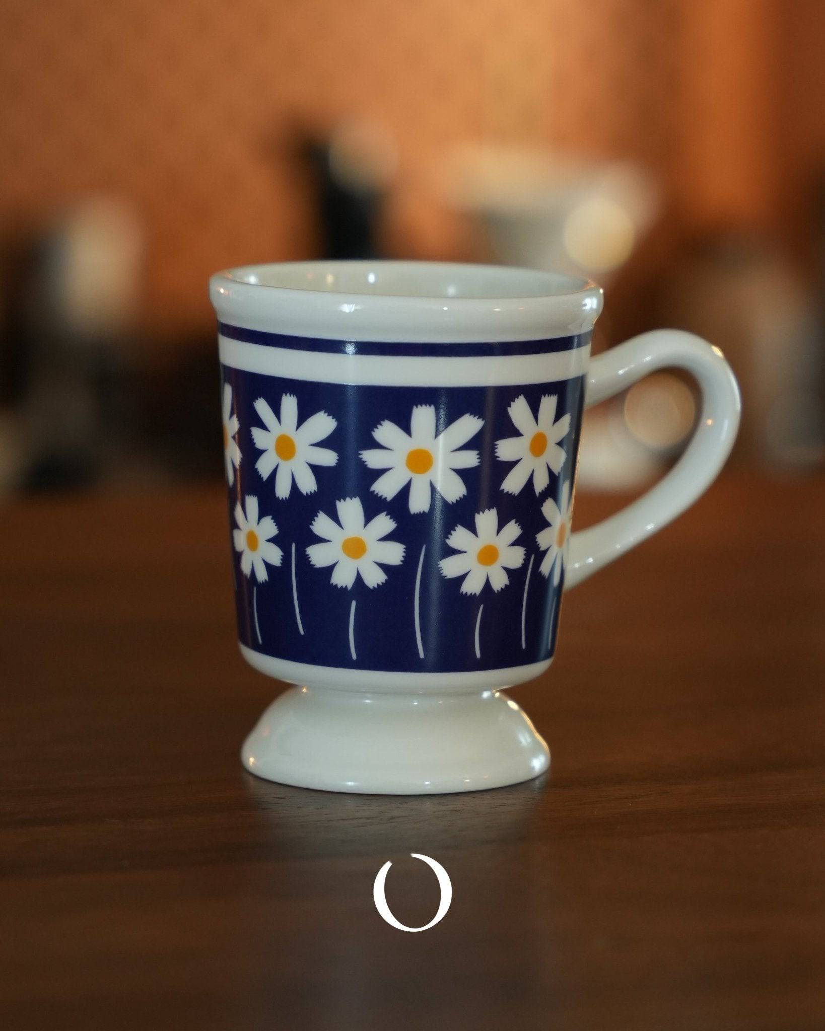 Vintage-style ceramic coffee cup with white daisy pattern on deep blue background, showcasing Showa era design, perfect for coffee, tea, or milk