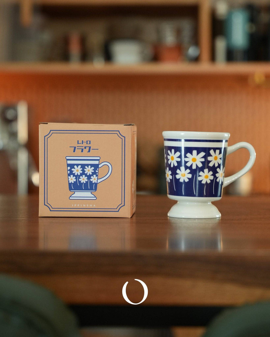 Vintage-style deep blue coffee cup with white daisy pattern, displayed next to its packaging box on wooden surface. Retro Showa-era inspired design, 250ml capacity, perfect for coffee, tea, or milk.