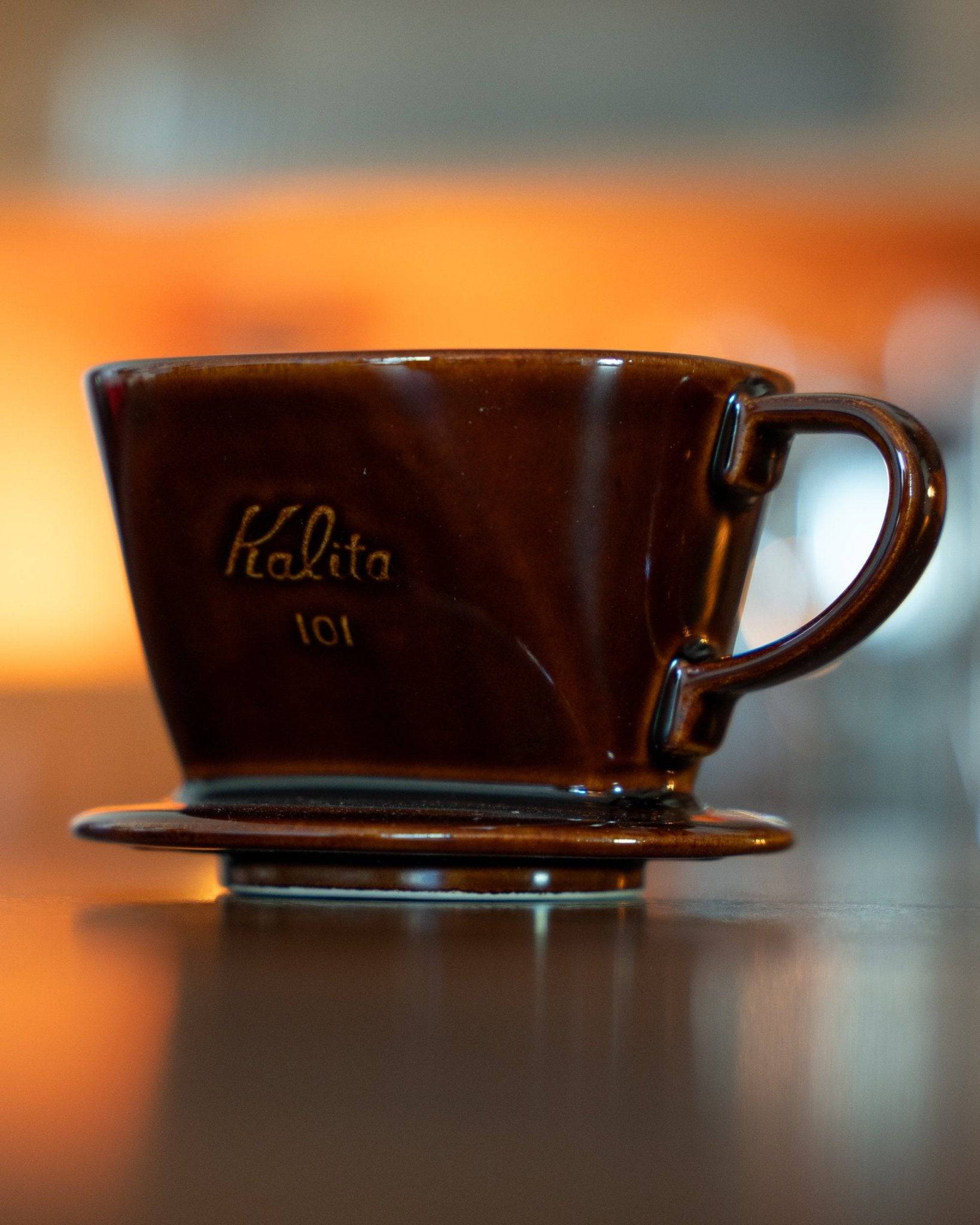 Kalita 101 brown ceramic coffee dripper with distinctive conical shape and engraved logo, showcasing its high-quality Japanese craftsmanship and design for optimal coffee brewing