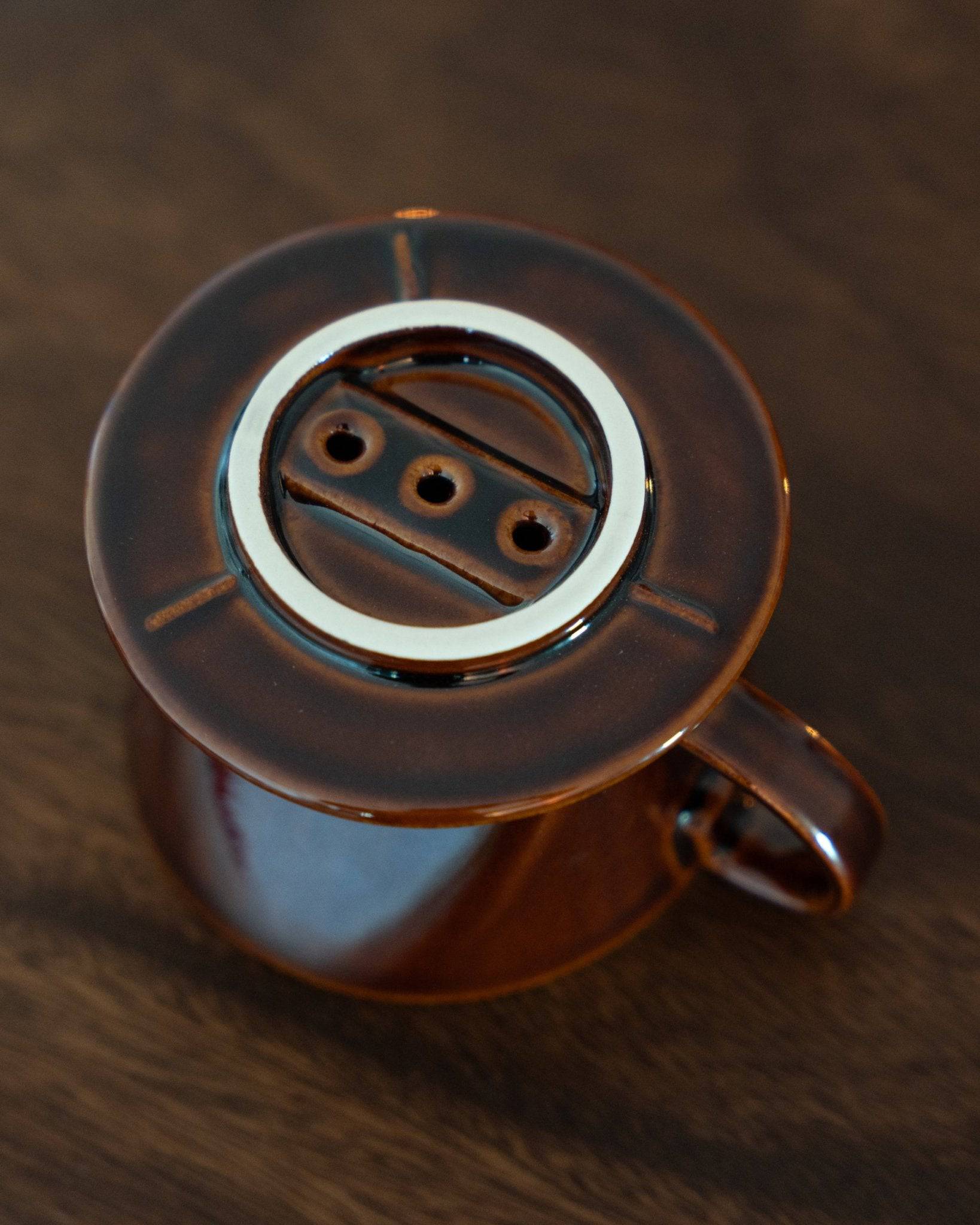 Kalita ceramic pour-over coffee dripper in brown, featuring a unique three-hole design and ribbed interior for optimal brewing. Japanese-made high-quality ceramic with smooth finish and excellent heat retention.