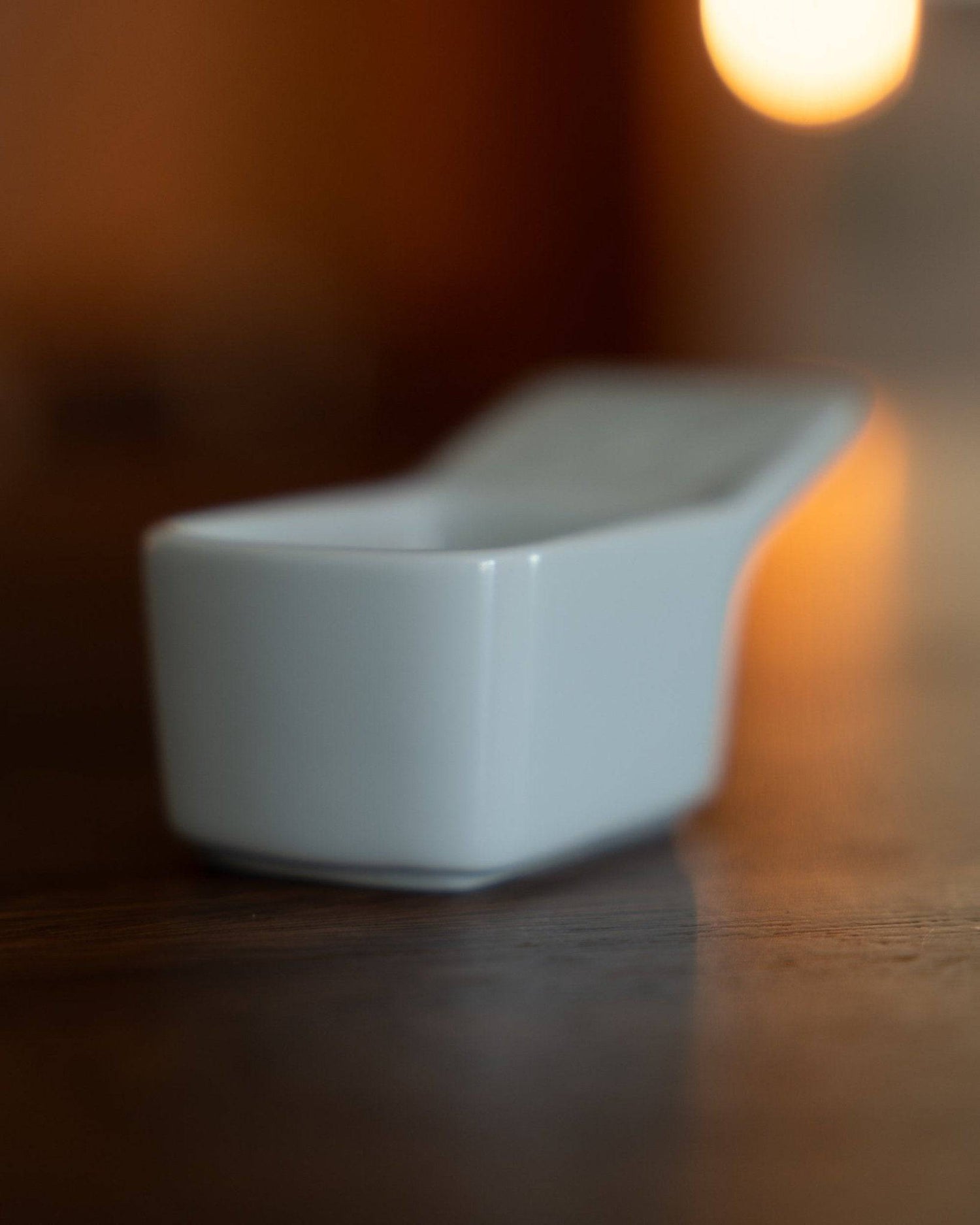 Kalita Hasami-yaki ceramic coffee scoop, 10g capacity, white porcelain with elegant design, on wooden surface in warm lighting, showcasing Japanese craftsmanship and precision for coffee enthusiasts
