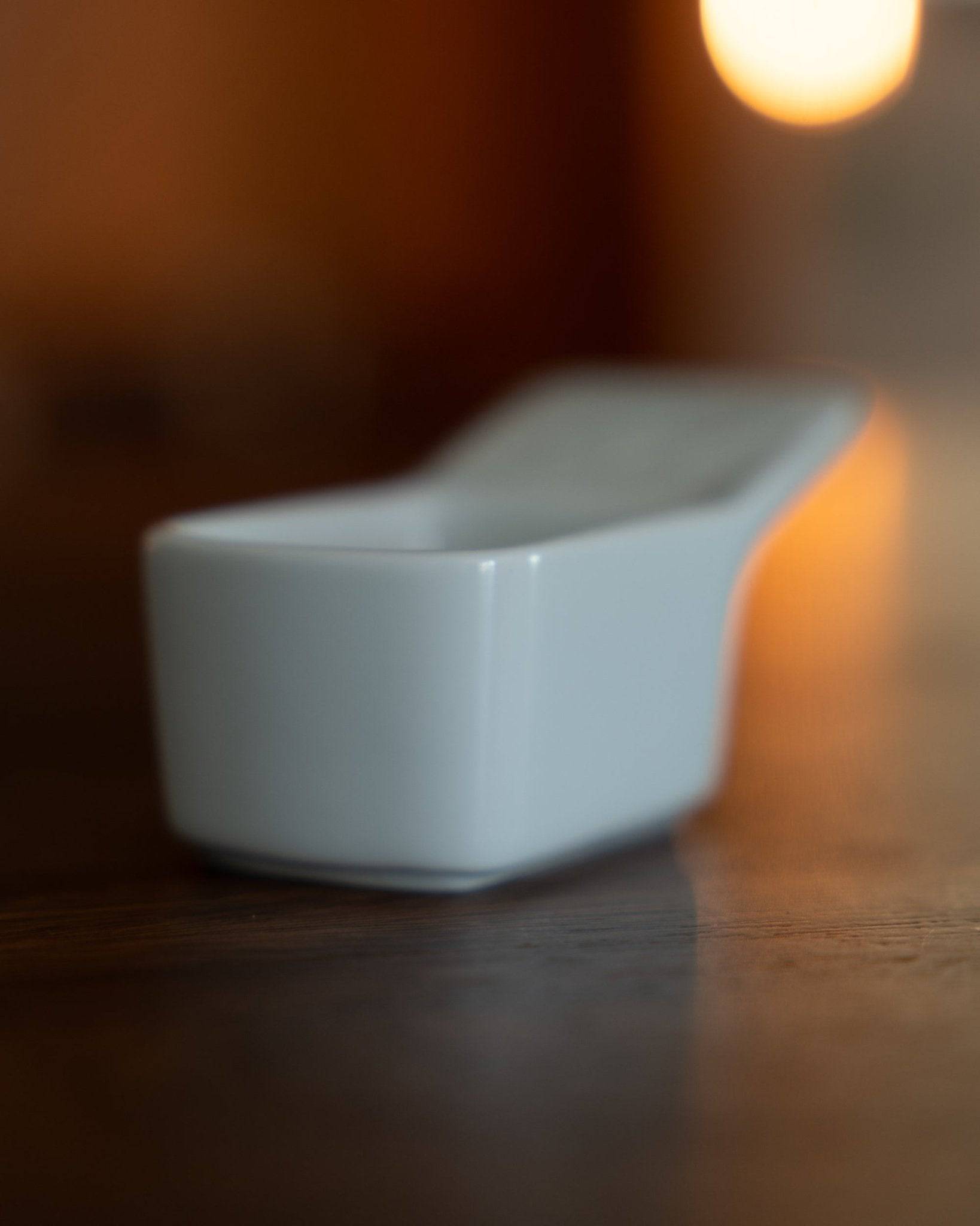 Kalita Hasami-yaki ceramic coffee scoop, 10g capacity, white porcelain with elegant design, on wooden surface in warm lighting, showcasing Japanese craftsmanship and precision for coffee enthusiasts