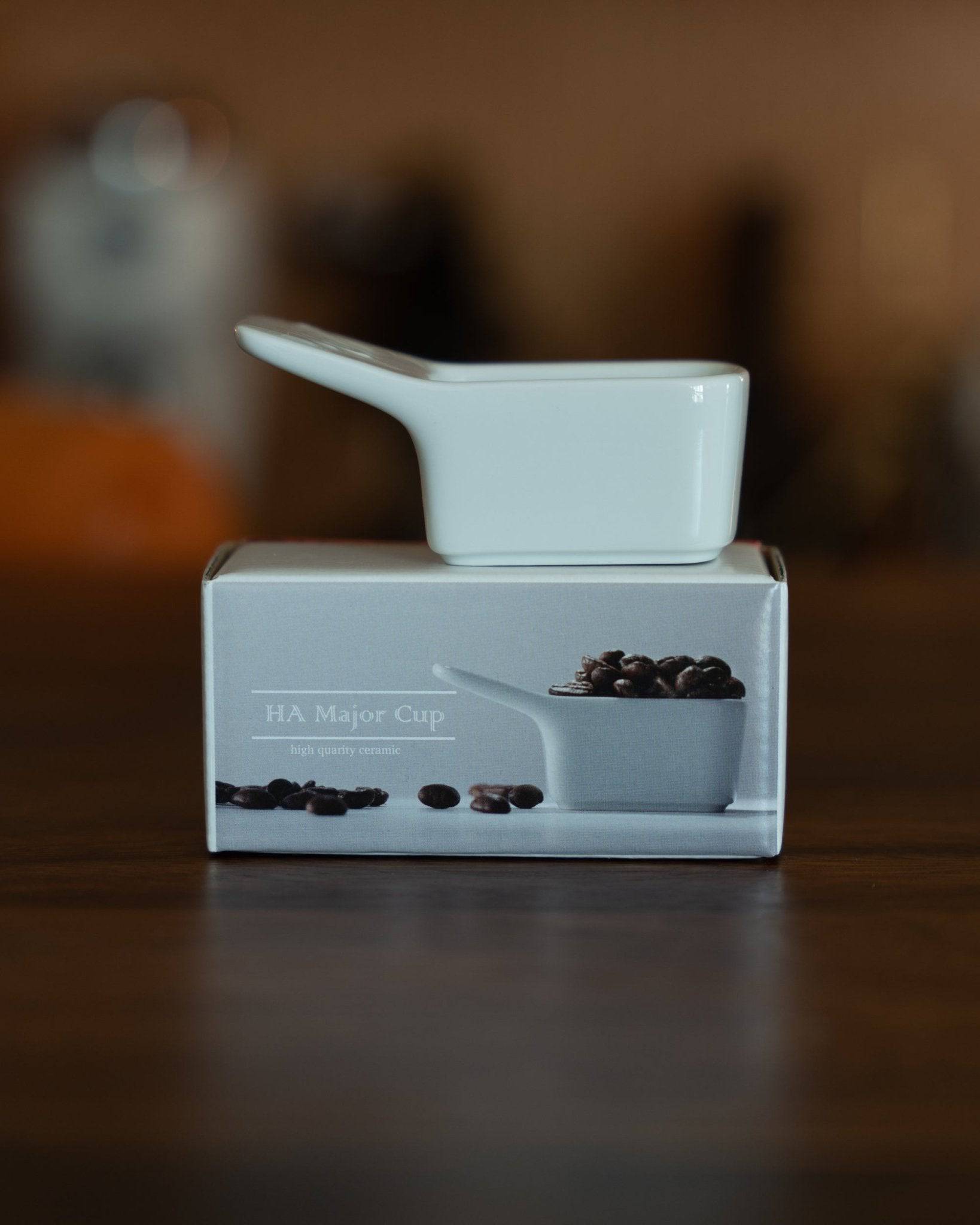 Kalita Hasami-yaki ceramic coffee scoop, 10g capacity, displayed on its product box featuring an image of the scoop filled with coffee beans, showcasing its elegant design and precise measurement functionality