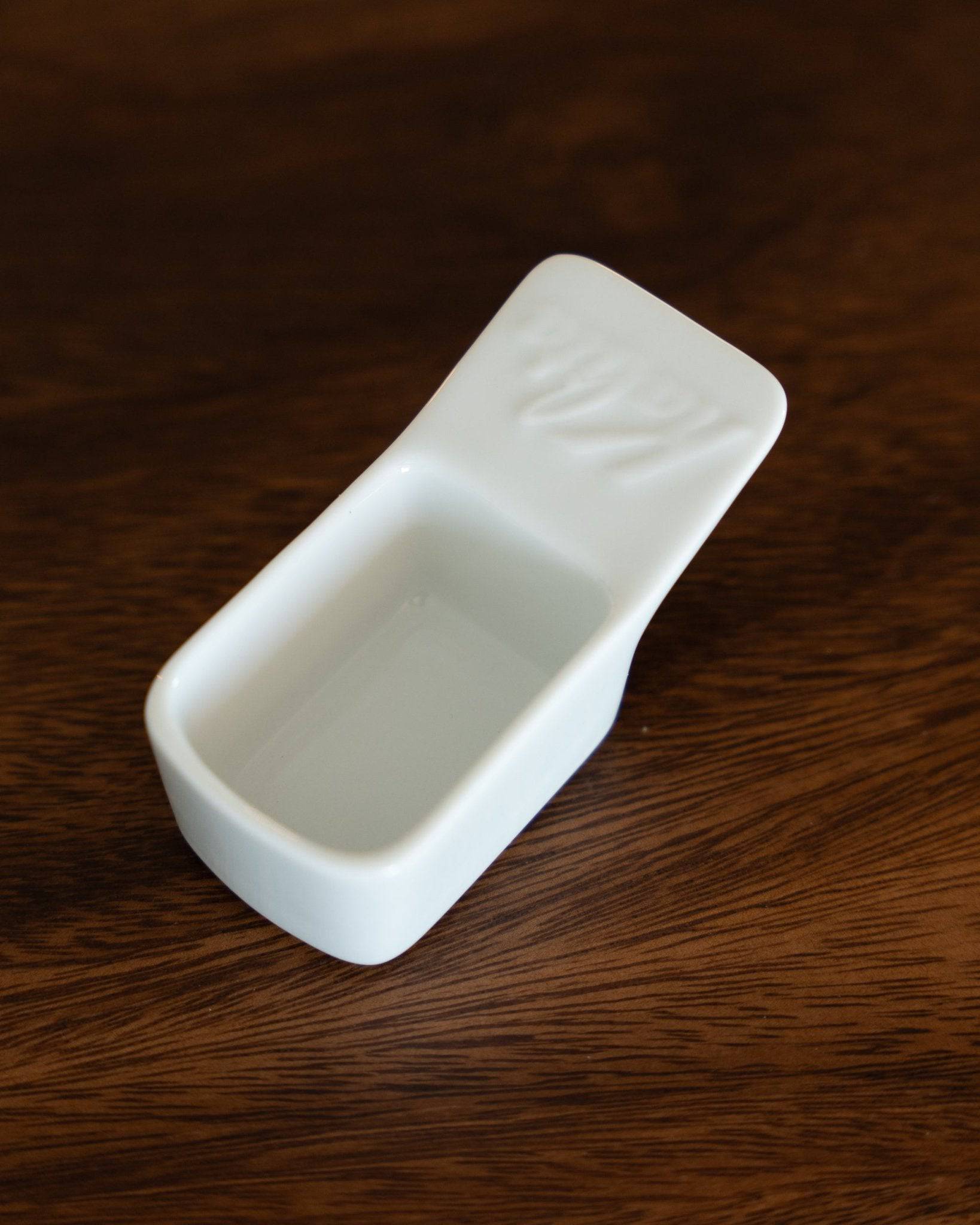 Kalita Hasami-yaki ceramic coffee scoop, 10g capacity, white rectangular design on wooden surface, Japanese craftsmanship, precise measuring tool for coffee enthusiasts