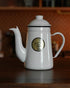 Kalita white enamel pour-over kettle with gooseneck spout, 1L capacity, showcasing brand logo on wooden surface, ideal for precise coffee brewing