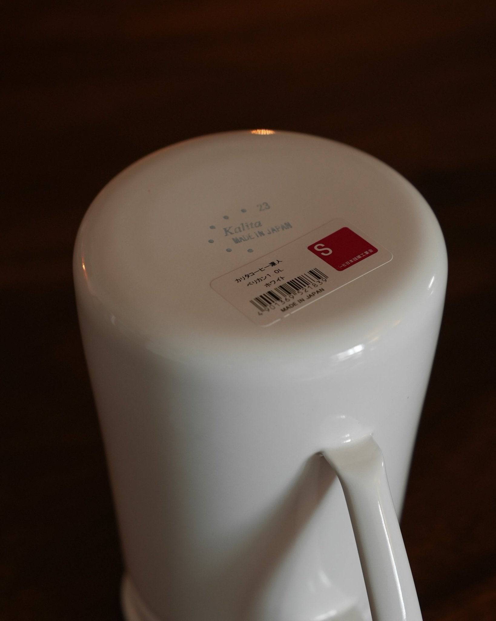 White Kalita enamel kettle base with product label and barcode, showcasing the high-quality craftsmanship and sleek design of the 1L pour-over coffee kettle