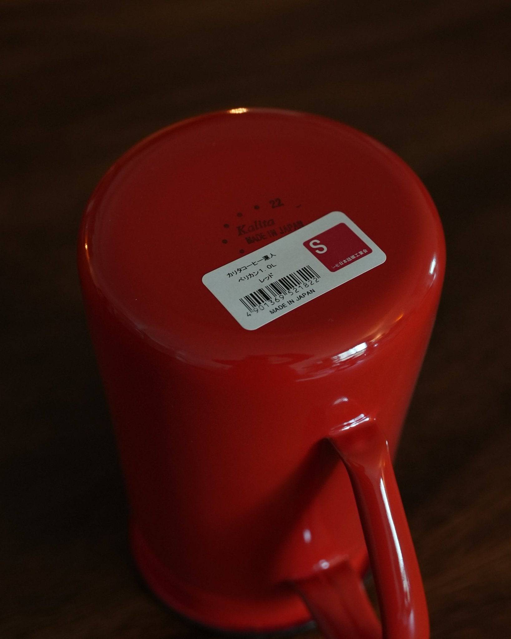 Vibrant red Kalita enamel pour-over kettle with gooseneck spout, 1L capacity, featuring price tag and product details on bottom, showcasing elegant design and high-quality craftsmanship for precision coffee brewing.