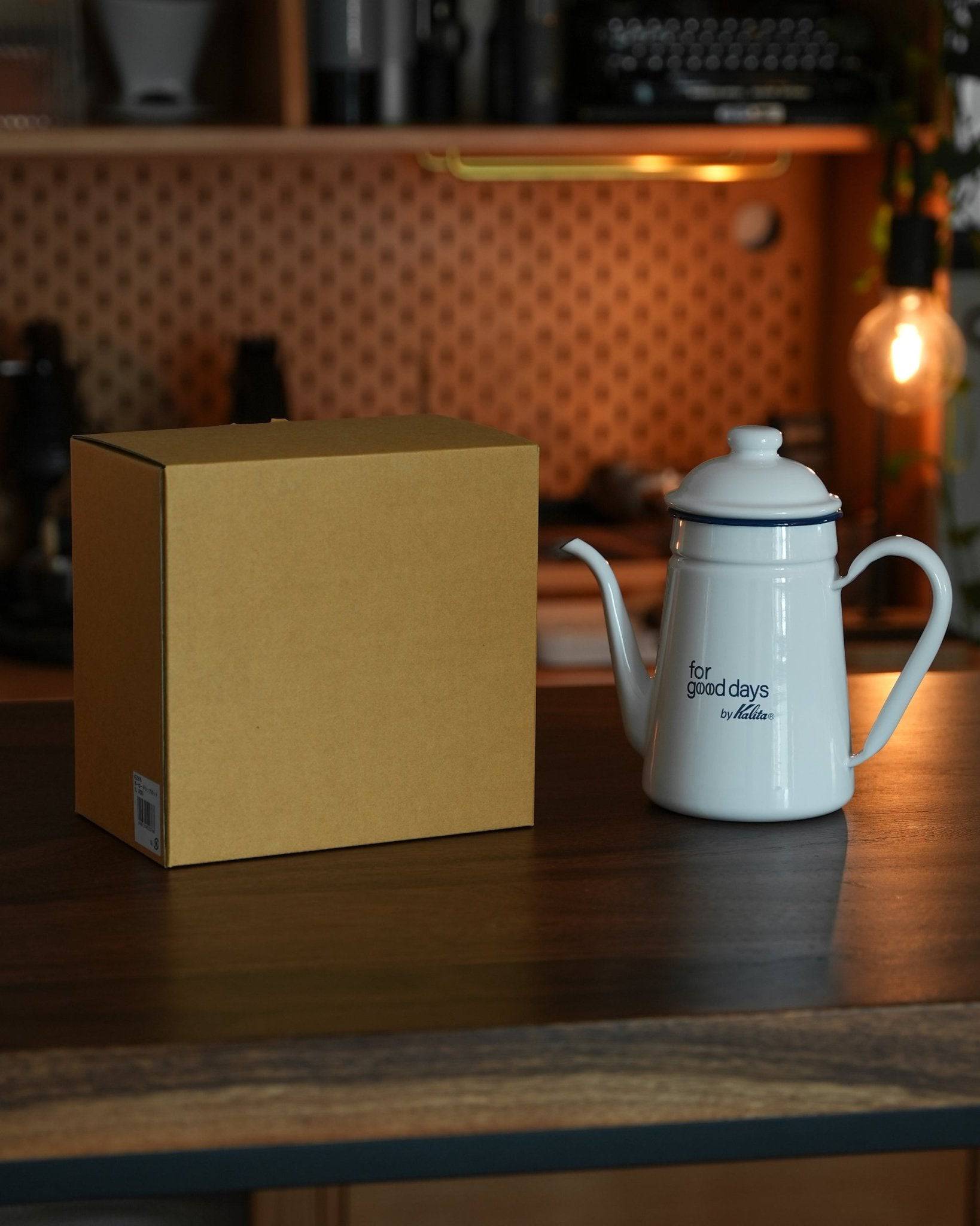 Kalita white enamel pour-over kettle 1L limited edition with packaging box on wooden counter in cozy kitchen setting