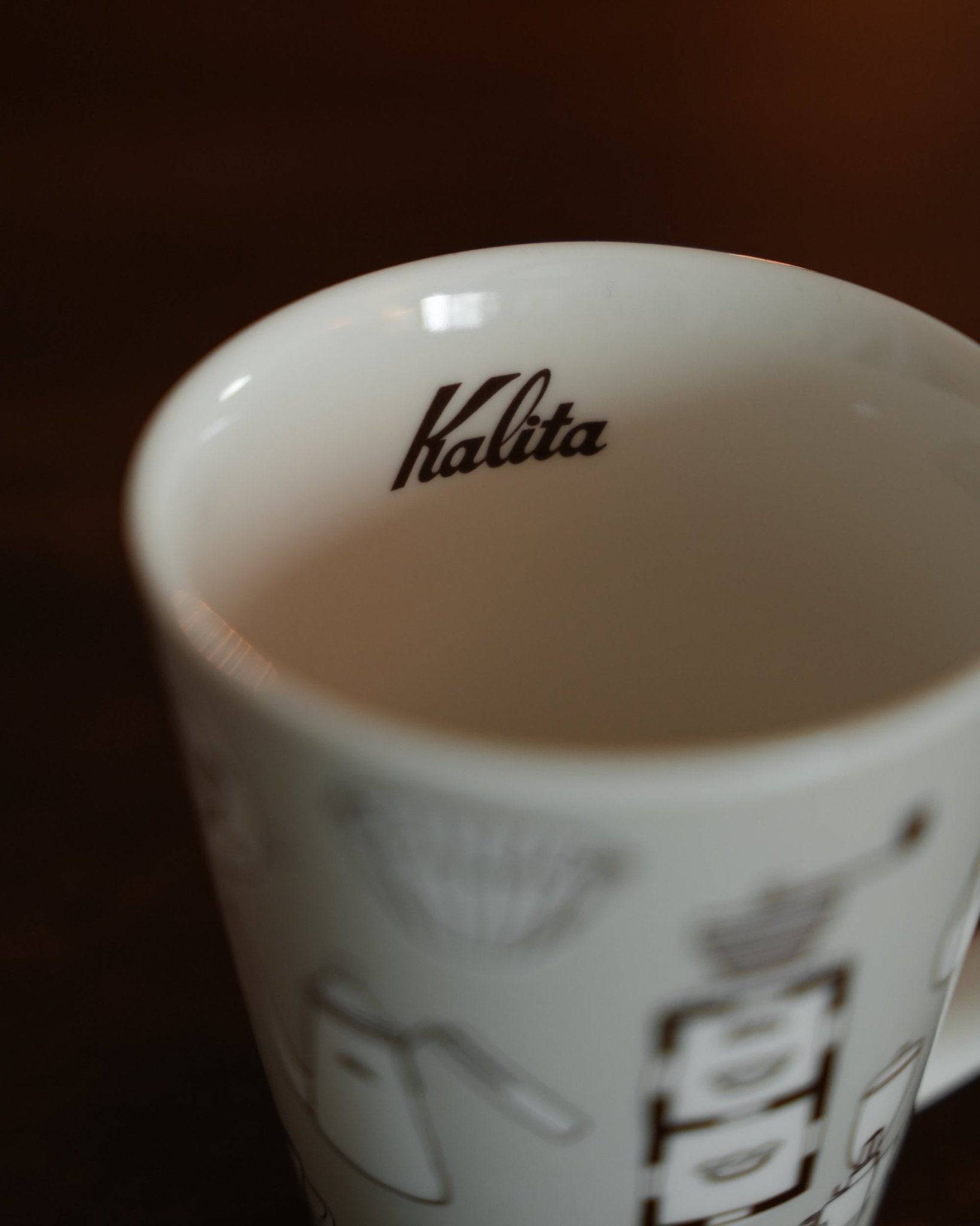 Kalita ceramic mug in warm gray, featuring brand logo inside and coffee equipment illustrations on exterior, showcasing elegant design and craftsmanship