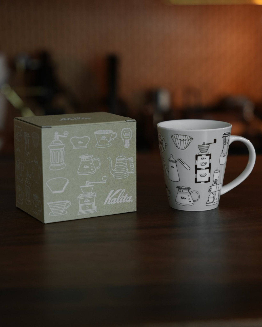 Kalita ceramic mug with coffee equipment illustrations next to its packaging box, showcasing the product&