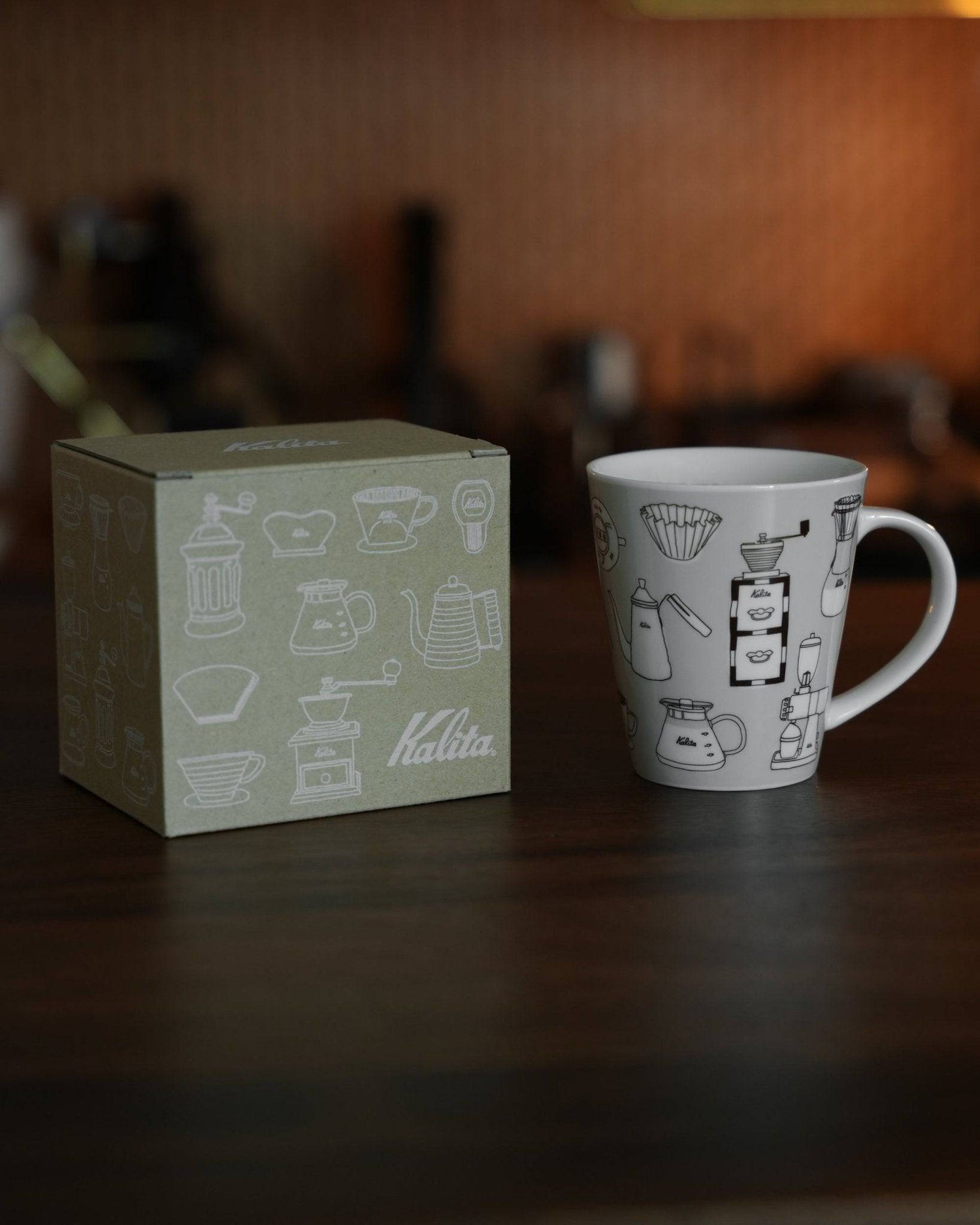 Kalita ceramic mug with coffee equipment illustrations next to its packaging box, showcasing the product&