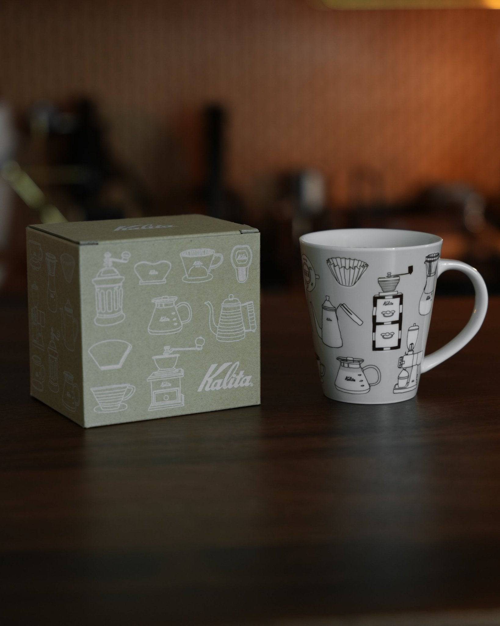 Kalita ceramic mug with coffee equipment illustrations next to its packaging box, showcasing the product&