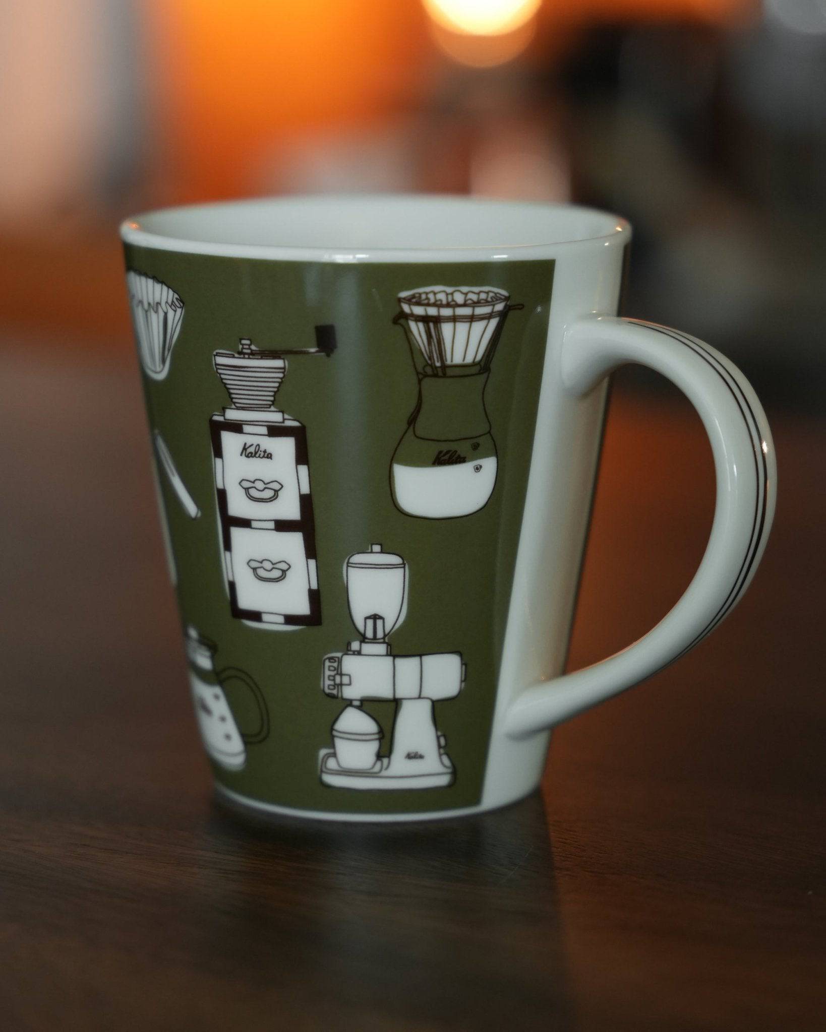 Kalita ceramic mug with illustrated coffee equipment designs on green background, 300ml capacity, khaki color, warm lighting ambiance