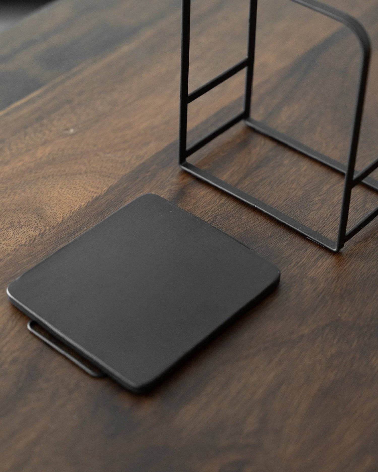 Kalita adjustable coffee dripper stand with detachable black metal base plate on wooden surface, showcasing sleek design and customizable features for optimal brewing experience