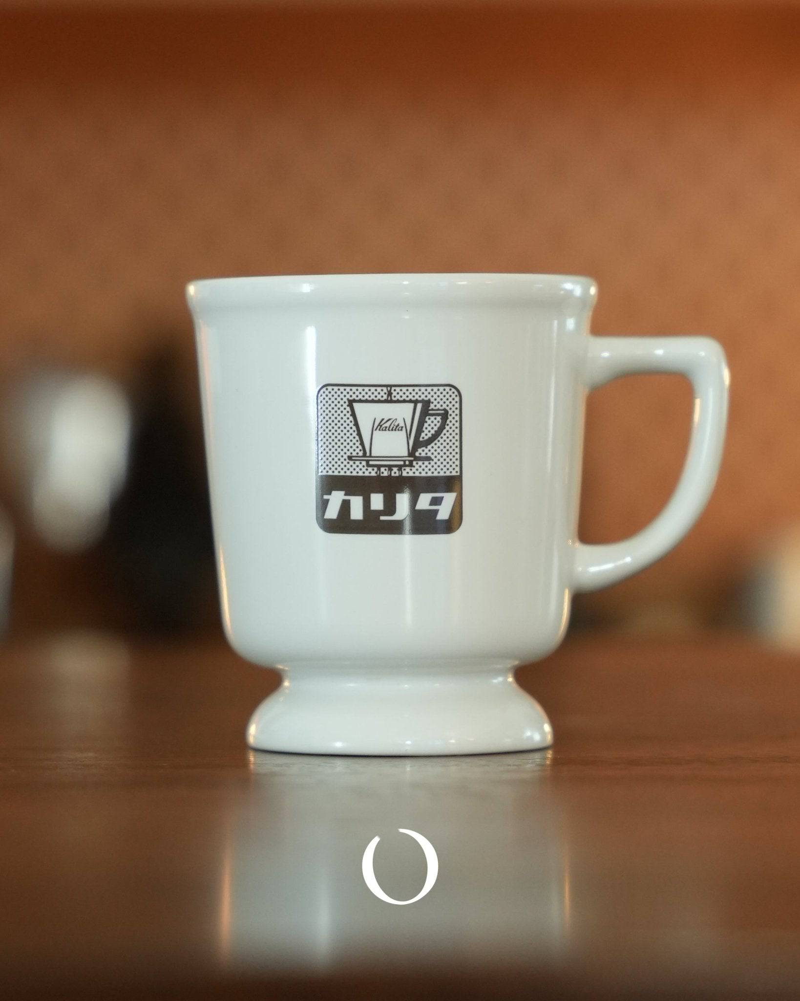 Kalita vintage coffee cup in white ceramic with retro logo, showcasing Showa era design, on wooden surface with warm background, perfect for nostalgic coffee experience