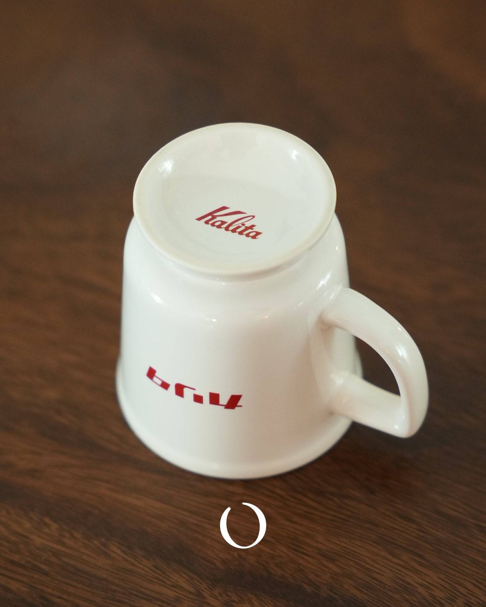 Kalita vintage coffee mug in white ceramic with red logo, featuring Showa era design, wide mouth and raised bottom for comfortable drinking, placed on wooden surface