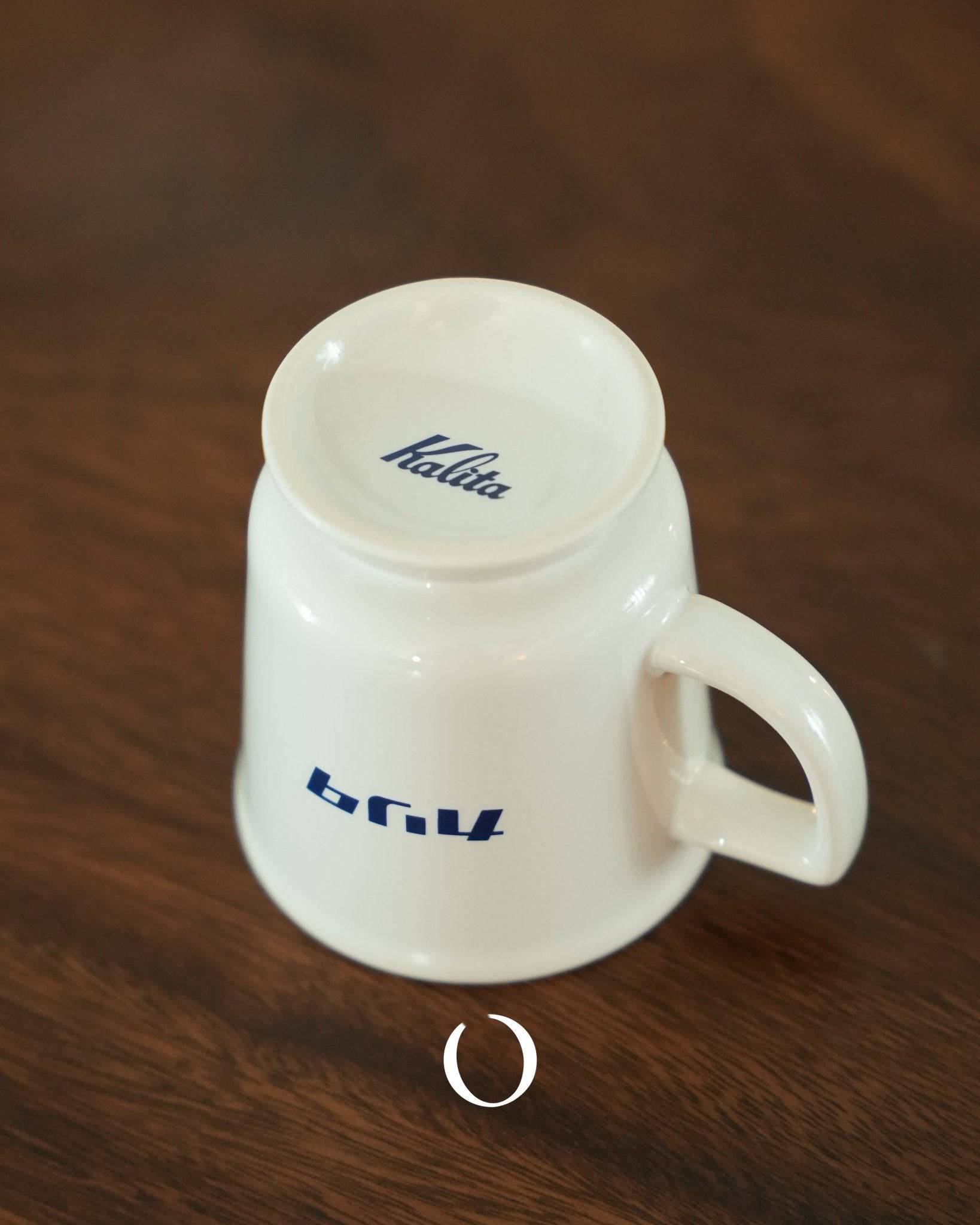 Kalita vintage coffee cup in white ceramic with blue logo and text, featuring a wide mouth and raised bottom, showcasing Showa era classic design on a wooden surface