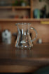 Kalita conical server 300 glass coffee carafe on wooden table in kitchen setting, showcasing heat-resistant design and Kalita logo