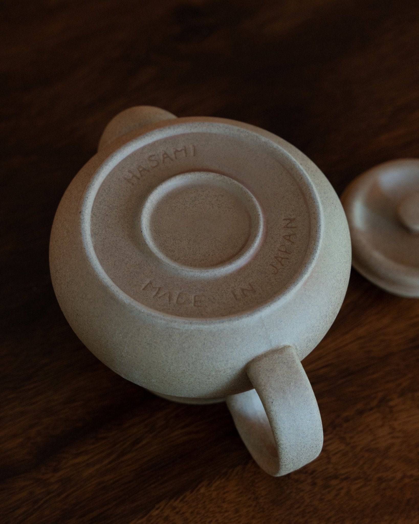Kalita & HASAMI sandstone coffee pot, 700ml capacity, made in Japan, with textured beige surface and circular lid design, showcasing traditional craftsmanship and modern aesthetics for coffee enthusiasts