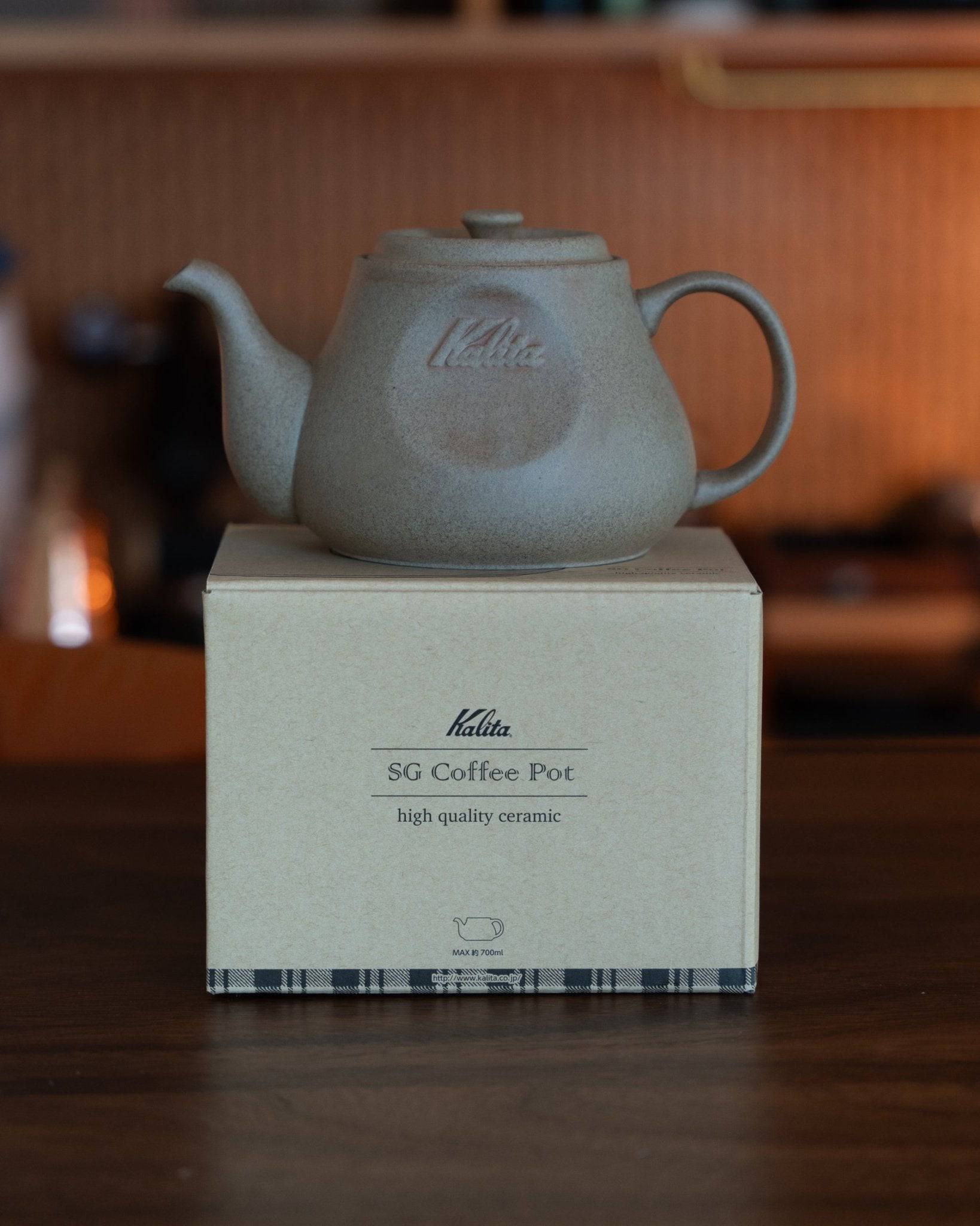 Kalita & HASAMI sandstone coffee pot, 700ml capacity, showcasing traditional Hasami-yaki craftsmanship. Matte gray ceramic teapot with Kalita logo, positioned on its product box highlighting high-quality ceramic construction.