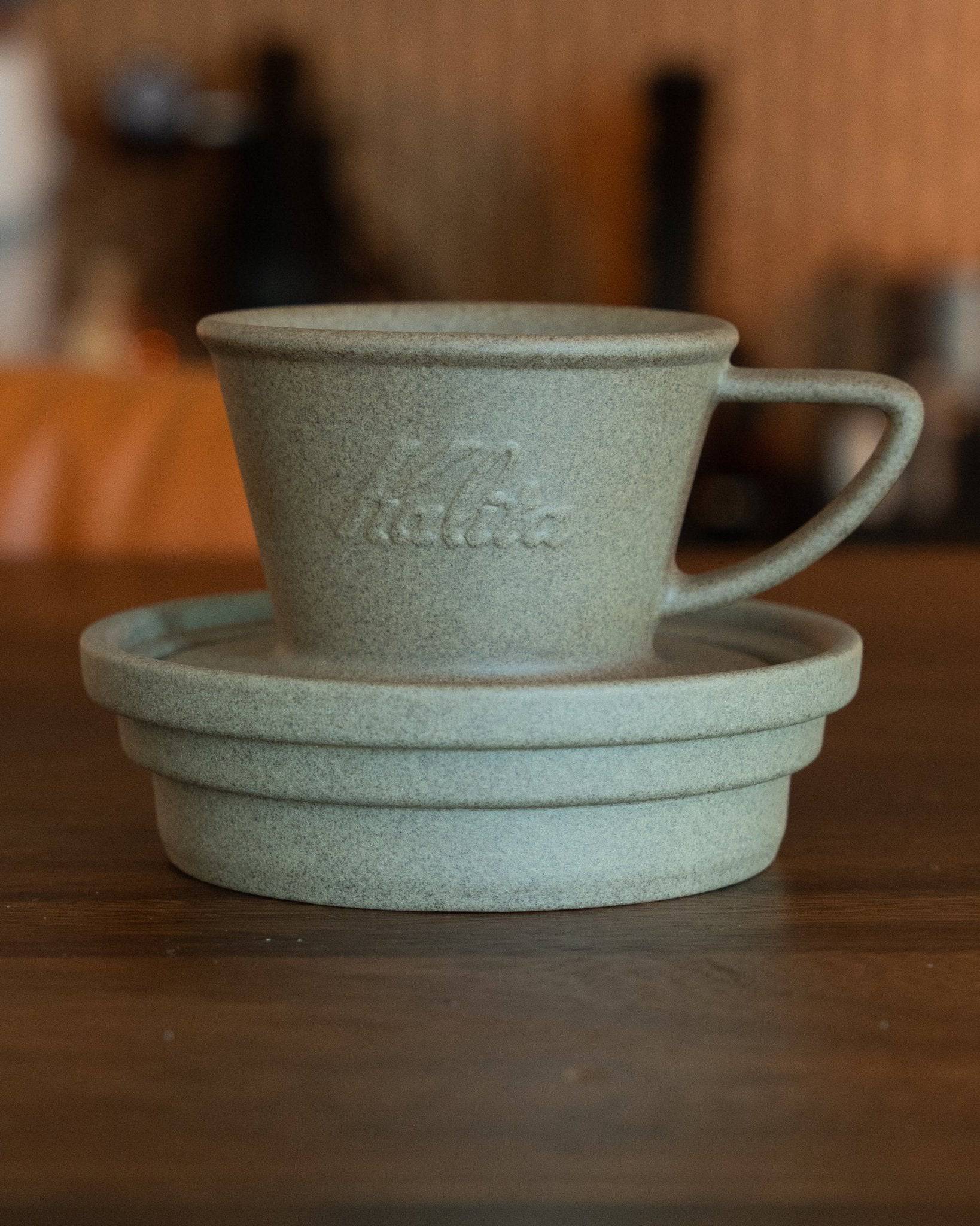 Kalita sandstone coffee dripper and saucer set, handcrafted Hasami-yaki ceramic in pale green, textured finish, showcasing Japanese craftsmanship and modern design for pour-over brewing