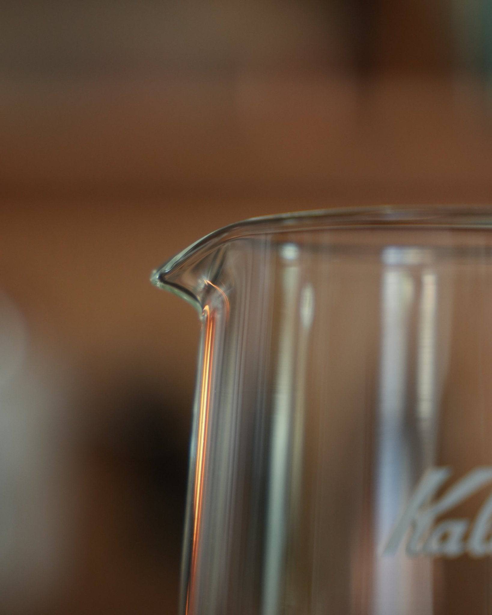 Close-up of Kalita JUG400 heat-resistant glass coffee pot, showcasing its elegant pour spout and transparent body with visible Kalita branding, highlighting the jug&