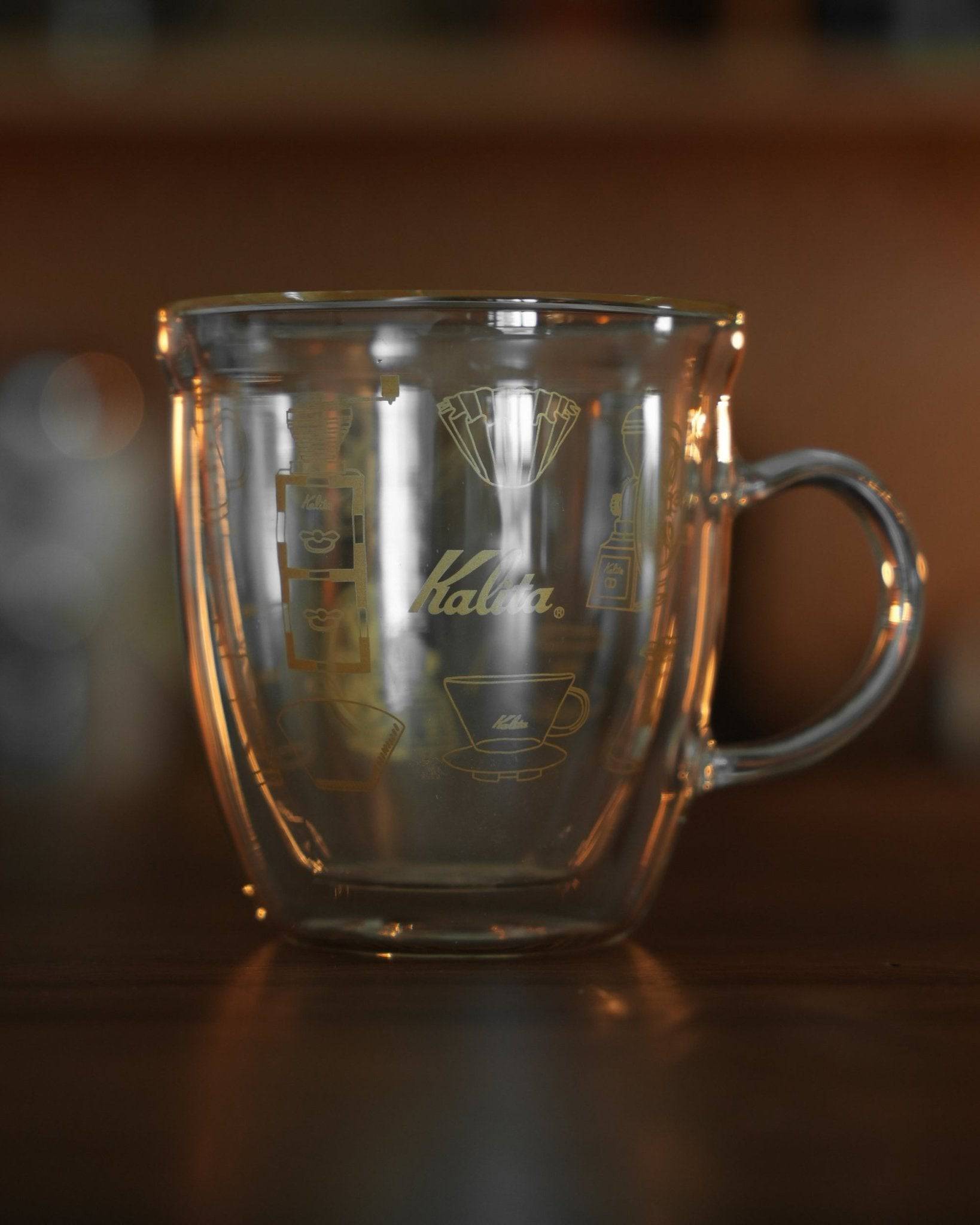 Kalita double-walled glass mug with coffee grinder and filter illustration, transparent design showcasing brand logo and coffee equipment graphics