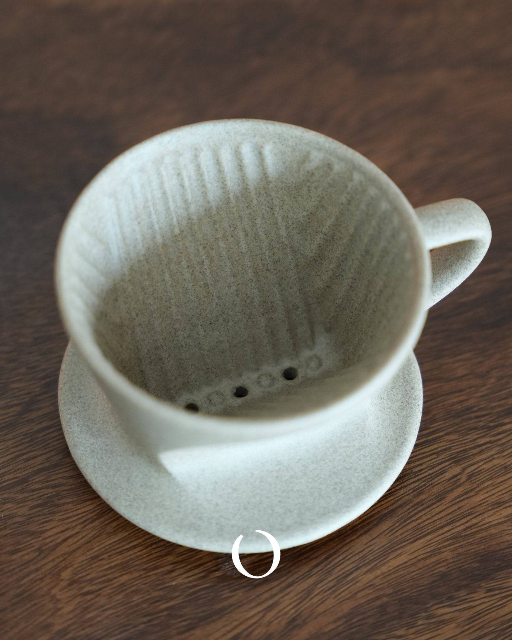 Kalita SG series sandstone ceramic pour-over coffee dripper, showcasing its unglazed texture, conical shape, and unique filter holes. Handcrafted using traditional Hasami-yaki technique, this dripper offers superior heat retention and even extraction for perfect coffee brewing.
