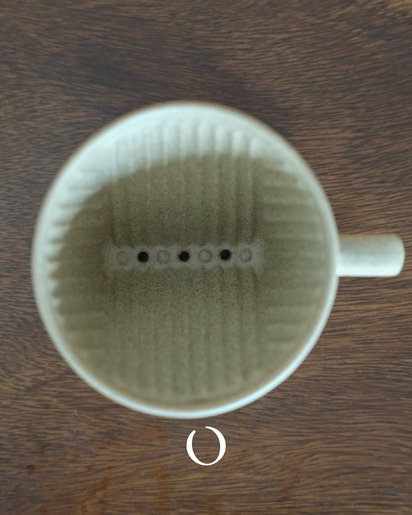 Kalita SG series sandstone ceramic pour-over coffee dripper, top view showing interior ribbed design and filter holes, crafted with Hasami-yaki technique, placed on wooden surface
