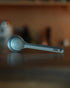 Kalita & Tsubame stainless steel coffee measuring spoon 10g (L Size) on wooden surface, showcasing its sleek design and matte finish, ideal for precise coffee measurement