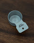 Kalita & Tsubame stainless steel coffee measuring scoop, 10g capacity, S Size, with matte finish and Kalita branding, placed on a dark wooden surface