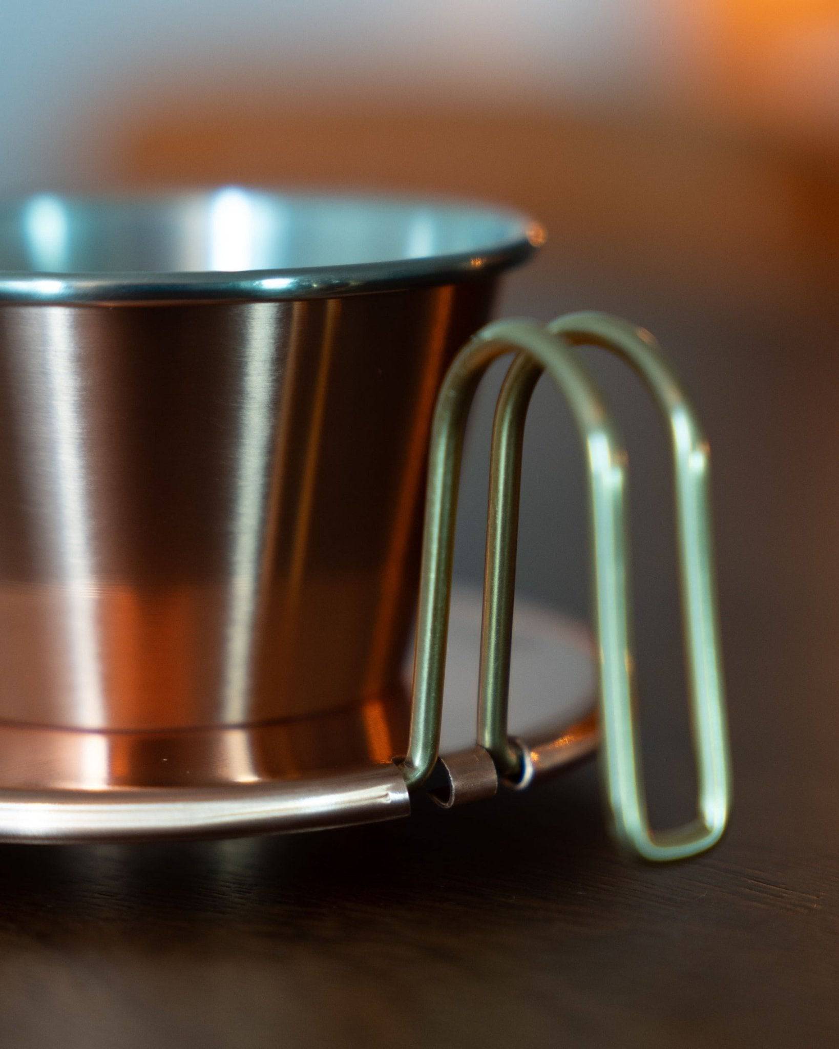 Close-up of Kalita & TSUBAME WDC-155 copper coffee dripper, showcasing its sleek metallic design and unique wire handle, highlighting the premium craftsmanship and heat-conductive properties of this Japanese-made pour-over coffee maker.